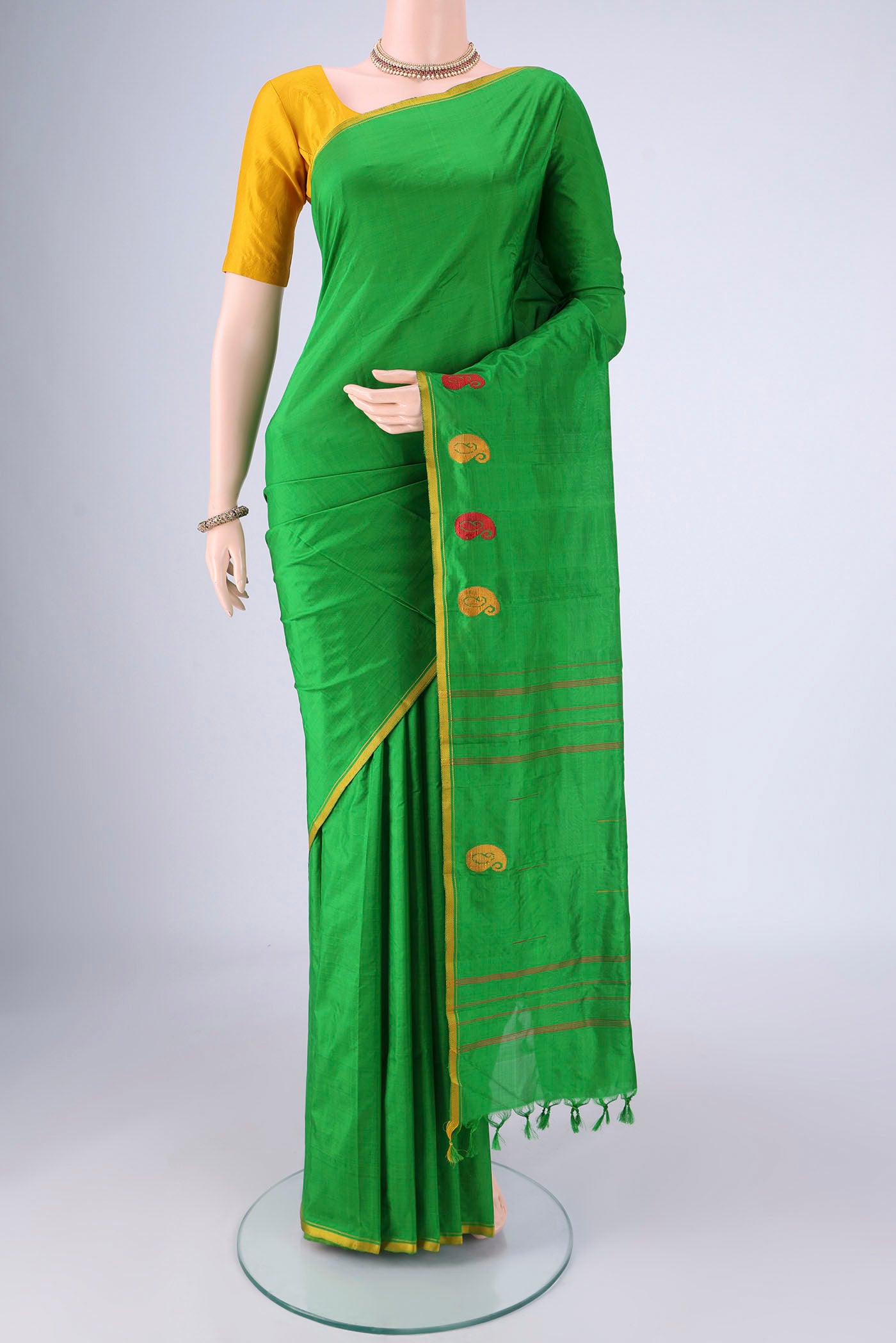Green Kanchipuram Silk Saree with Plain Body and Thread Border.  displayed on a mannequin