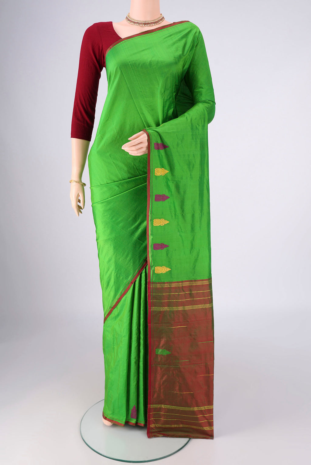 Green Kanchipuram Silk Saree with Plain Body and Thread Border.  displayed on a mannequin