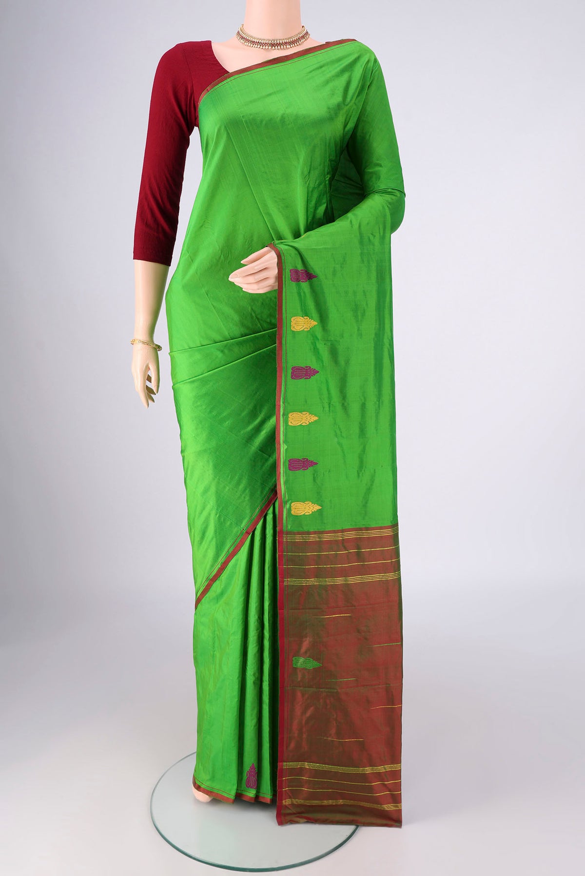 Green Kanchipuram Silk Saree with Plain Body and Thread Border.  displayed on a mannequin