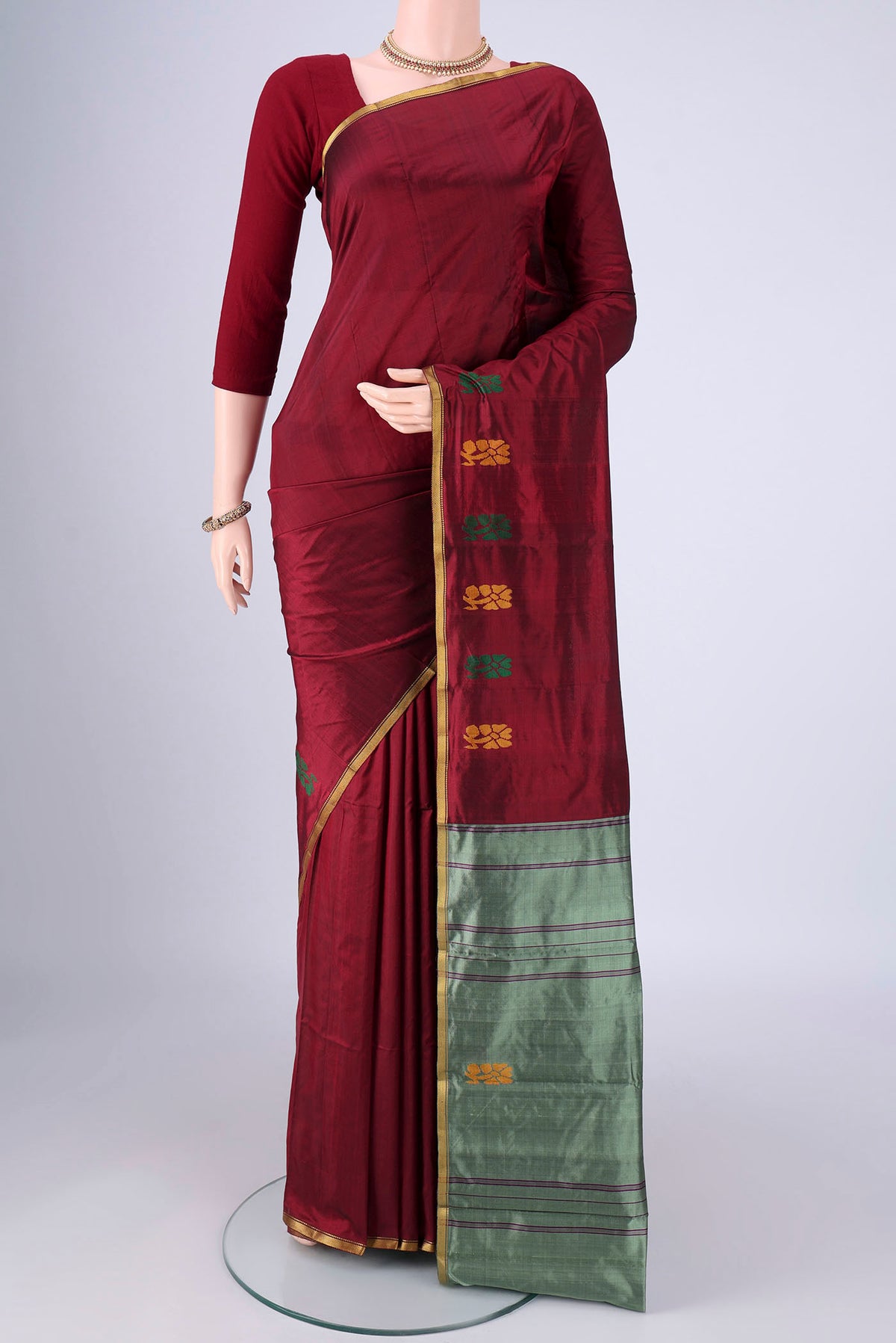 Maroon Kanchipuram Silk Saree with Plain Body and Zari Border.  displayed on a mannequin