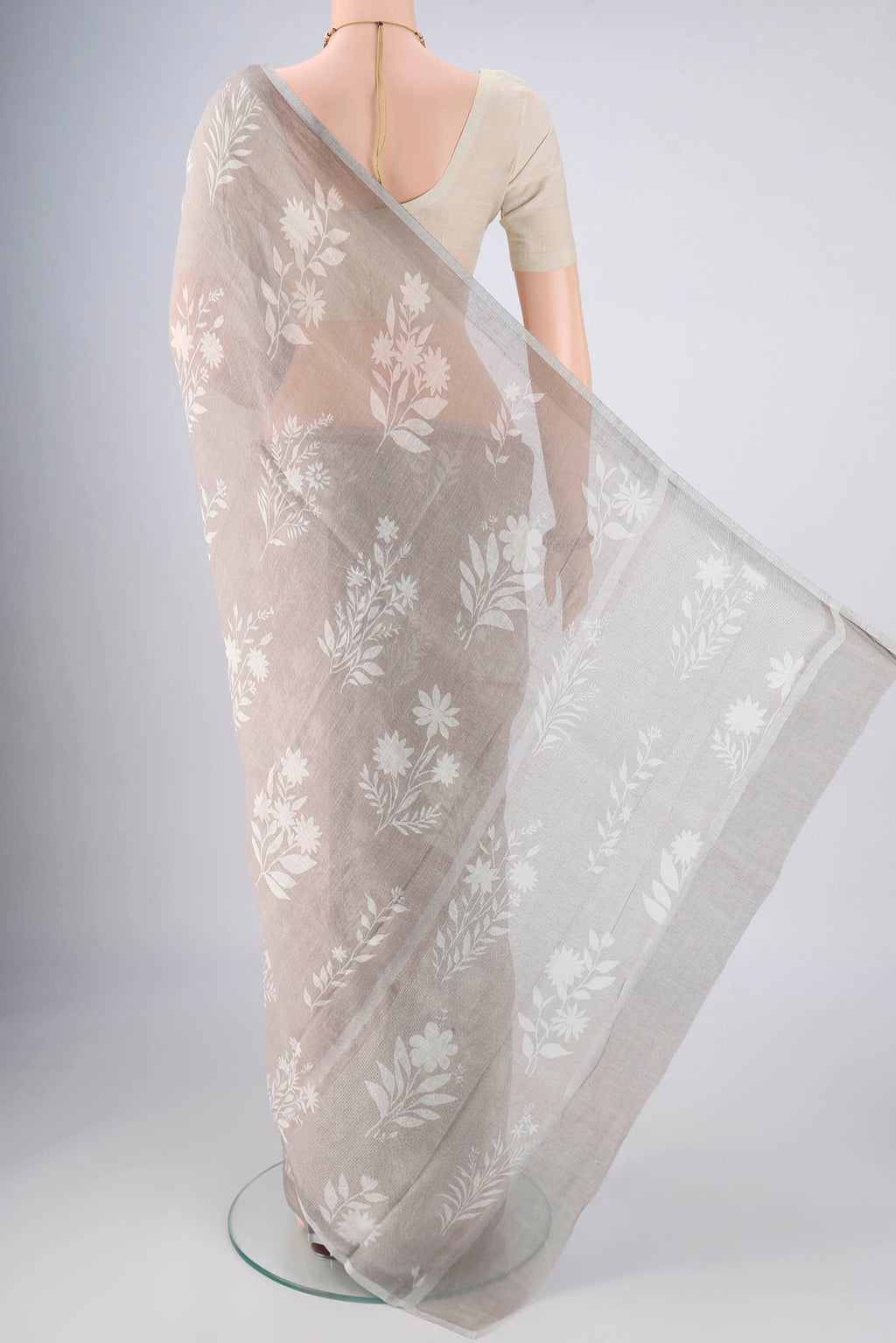 Flat view of Grey Linen Saree with Floral Print on the body and Zari Border. 