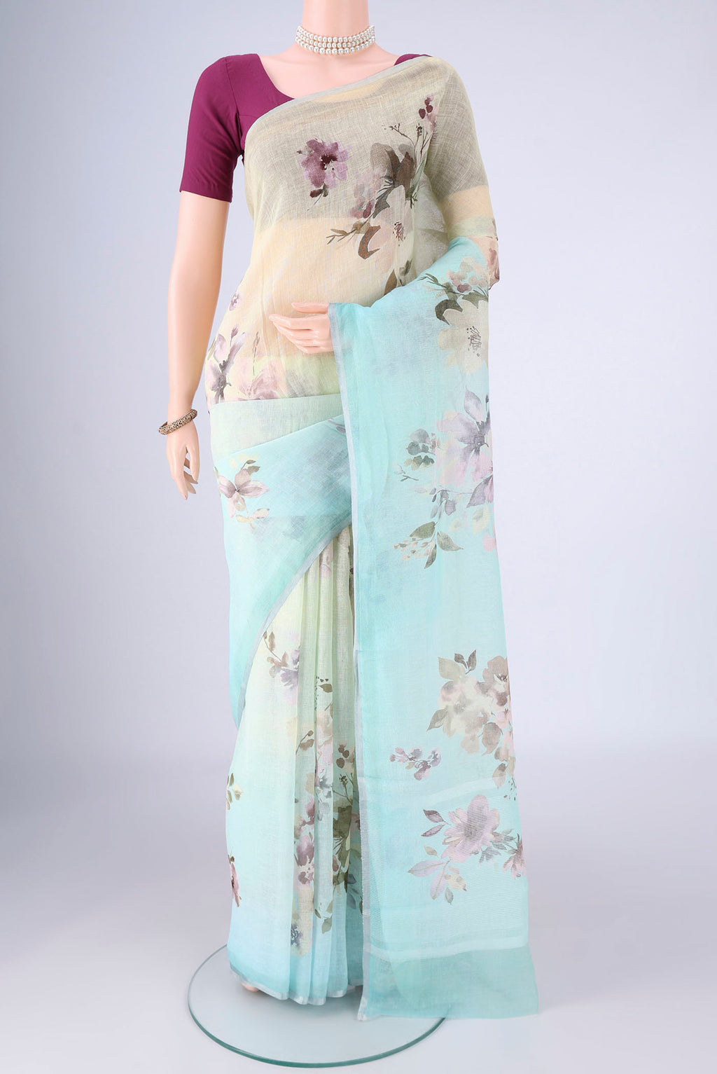 Sky Blue Linen Saree with Floral Print on the body and Zari Border.  displayed on a mannequin