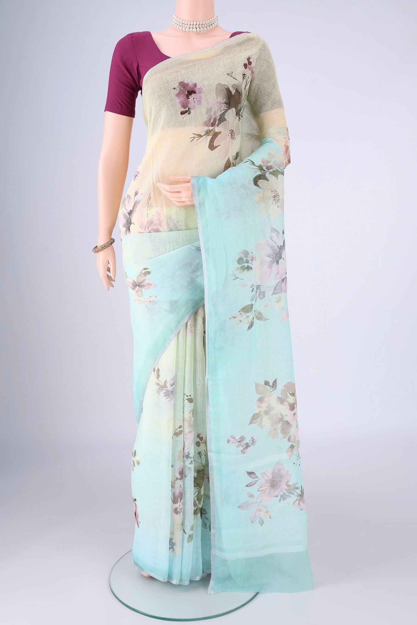 Sky Blue Linen Saree with Floral Print on the body and Zari Border.  displayed on a mannequin