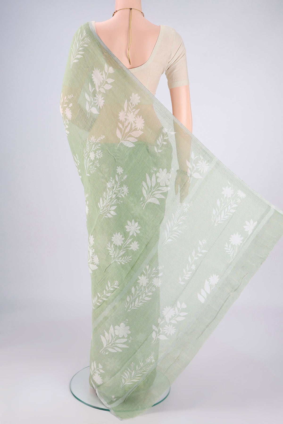 Flat view of Light Green Linen Saree with Floral Print on the body and Zari Border. 