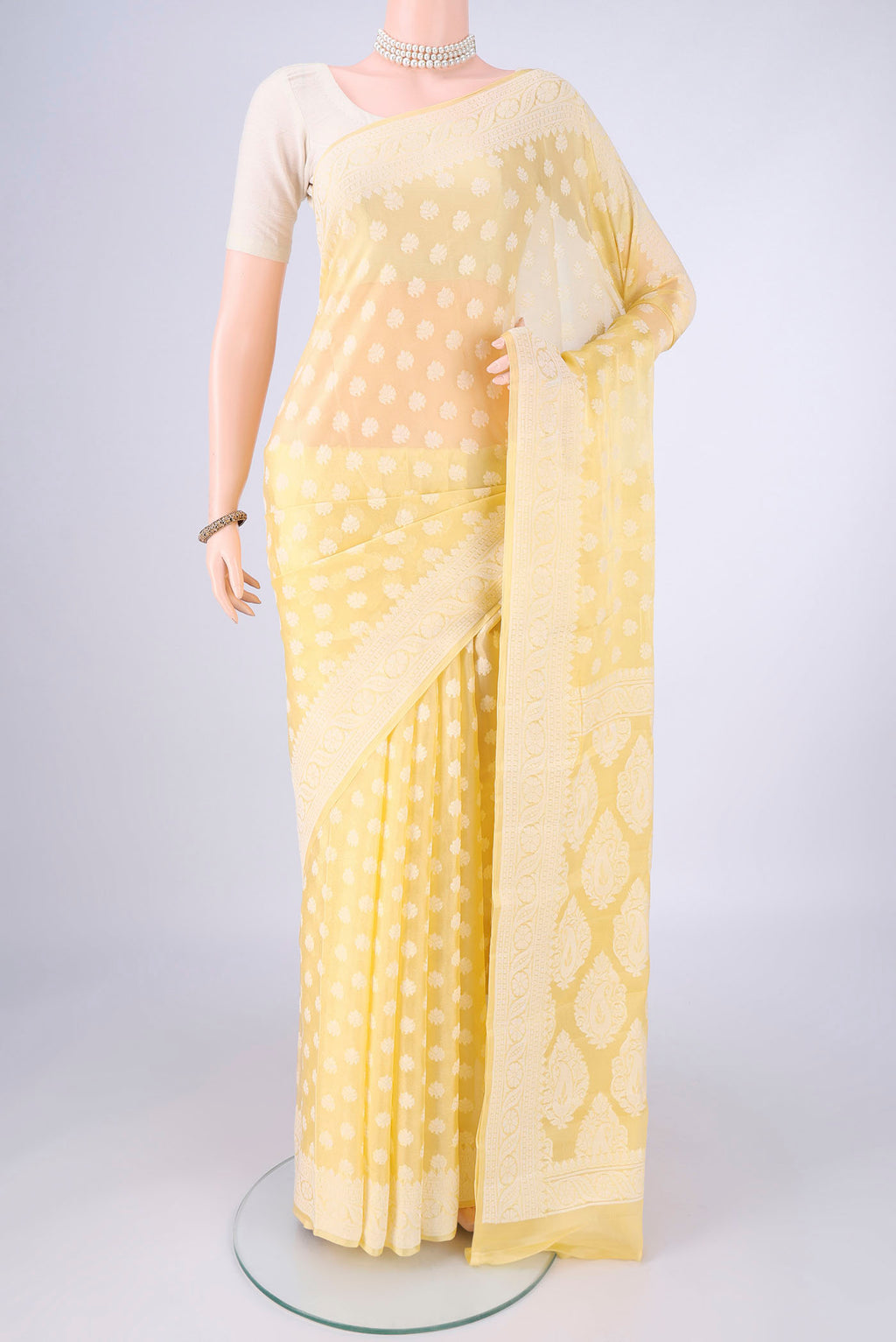 Lemon Yellow Blended Banarasi Georgette Saree with Thread Butta on the body and Thread Border.  displayed on a mannequin