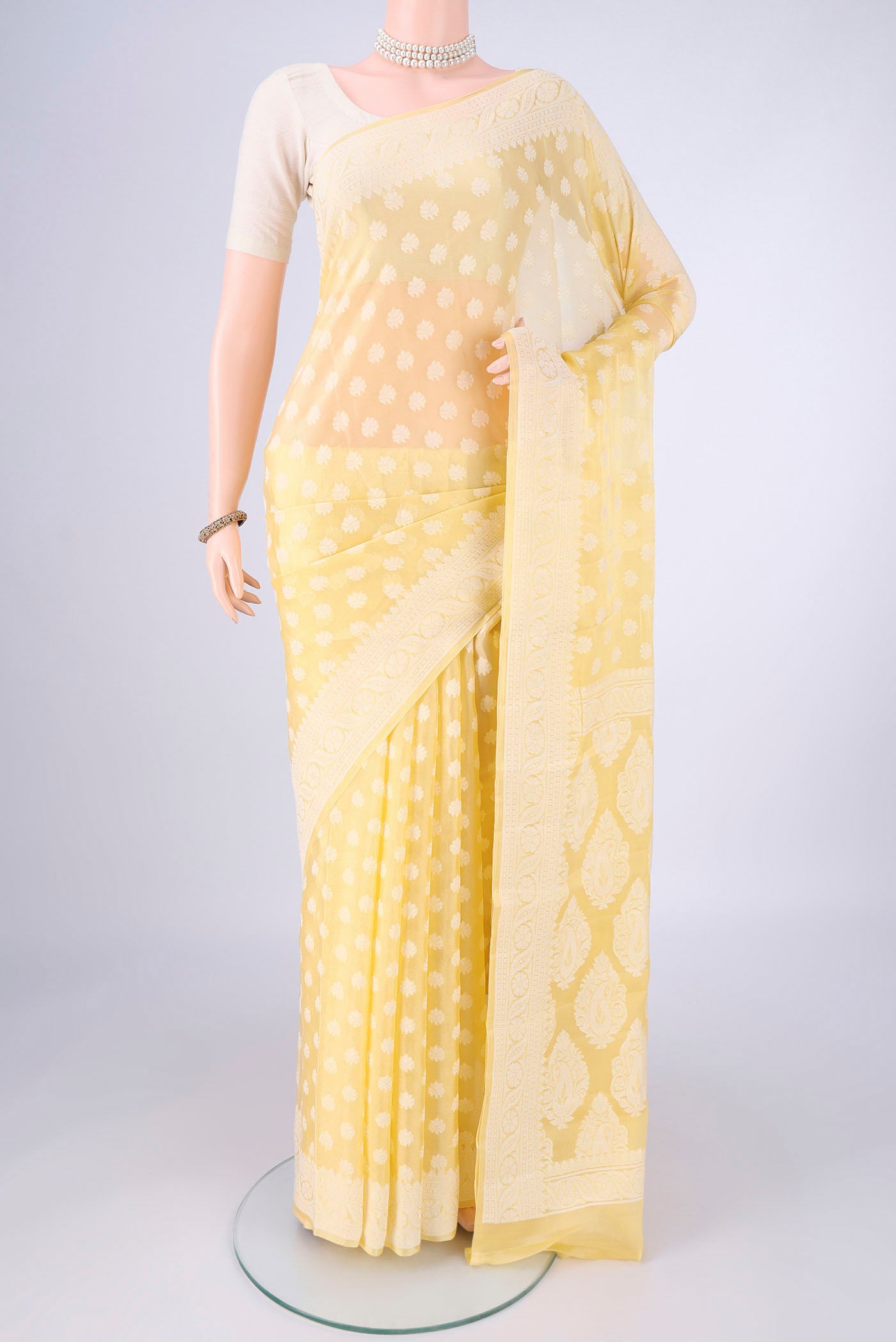 Lemon Yellow Blended Banarasi Georgette Saree with Thread Butta on the body and Thread Border.  displayed on a mannequin