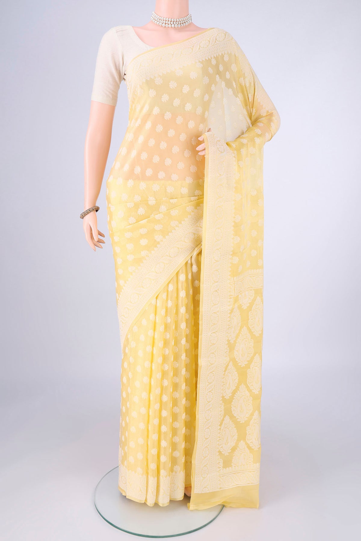 Lemon Yellow Blended Banarasi Georgette Saree with Thread Butta on the body and Thread Border.  displayed on a mannequin