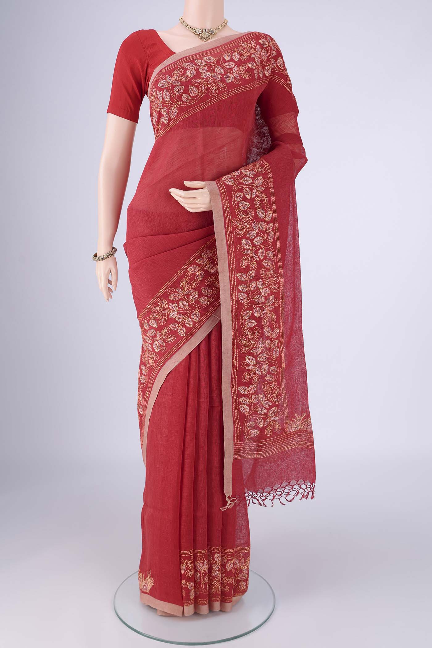 Rust Linen Cotton Saree with Kantha Work on the body and Thread Border.  displayed on a mannequin