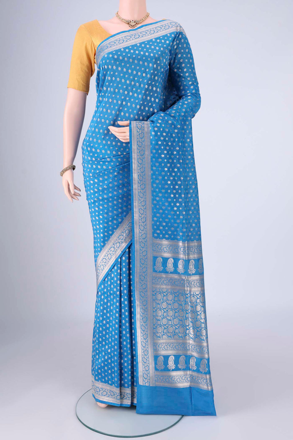 Electric Blue Banarasi Silk Saree with Zari Butta on the body and Zari Border.  displayed on a mannequin