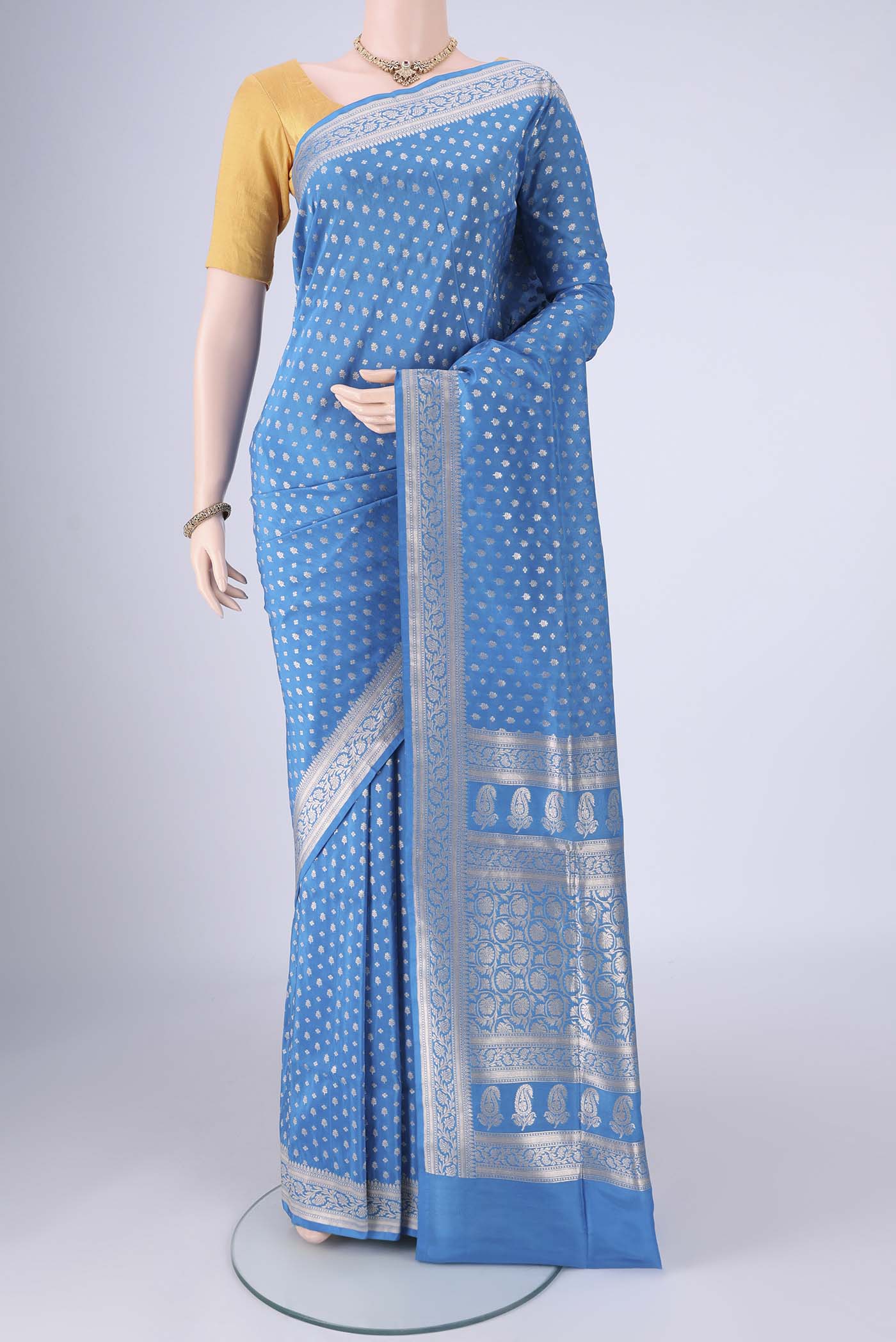 Electric Blue Banarasi Silk Saree with Zari Butta on the body and Zari Border.  displayed on a mannequin