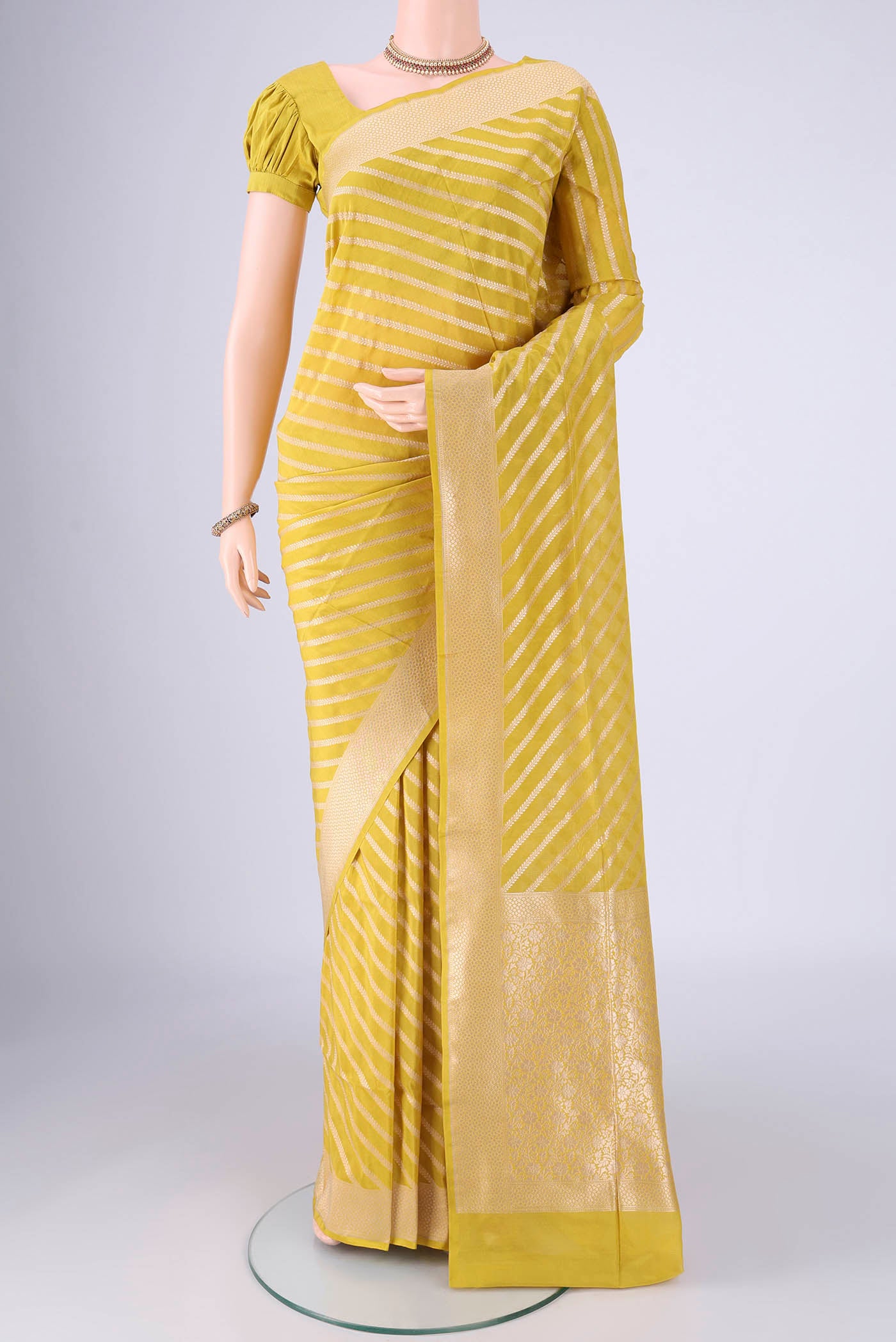 Yellow Banarasi Silk Saree with Stripes on the body and Zari Border.  displayed on a mannequin