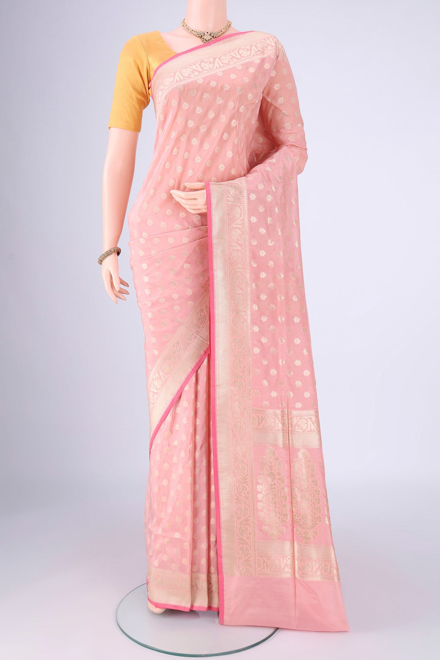 Peach Banarasi Silk Saree with Zari Butta on the body and Zari Border.  displayed on a mannequin
