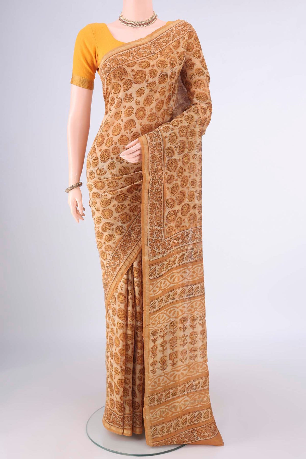 Beige Chanderi Cotton Saree with Batik Print on the body and Zari Border.  displayed on a mannequin