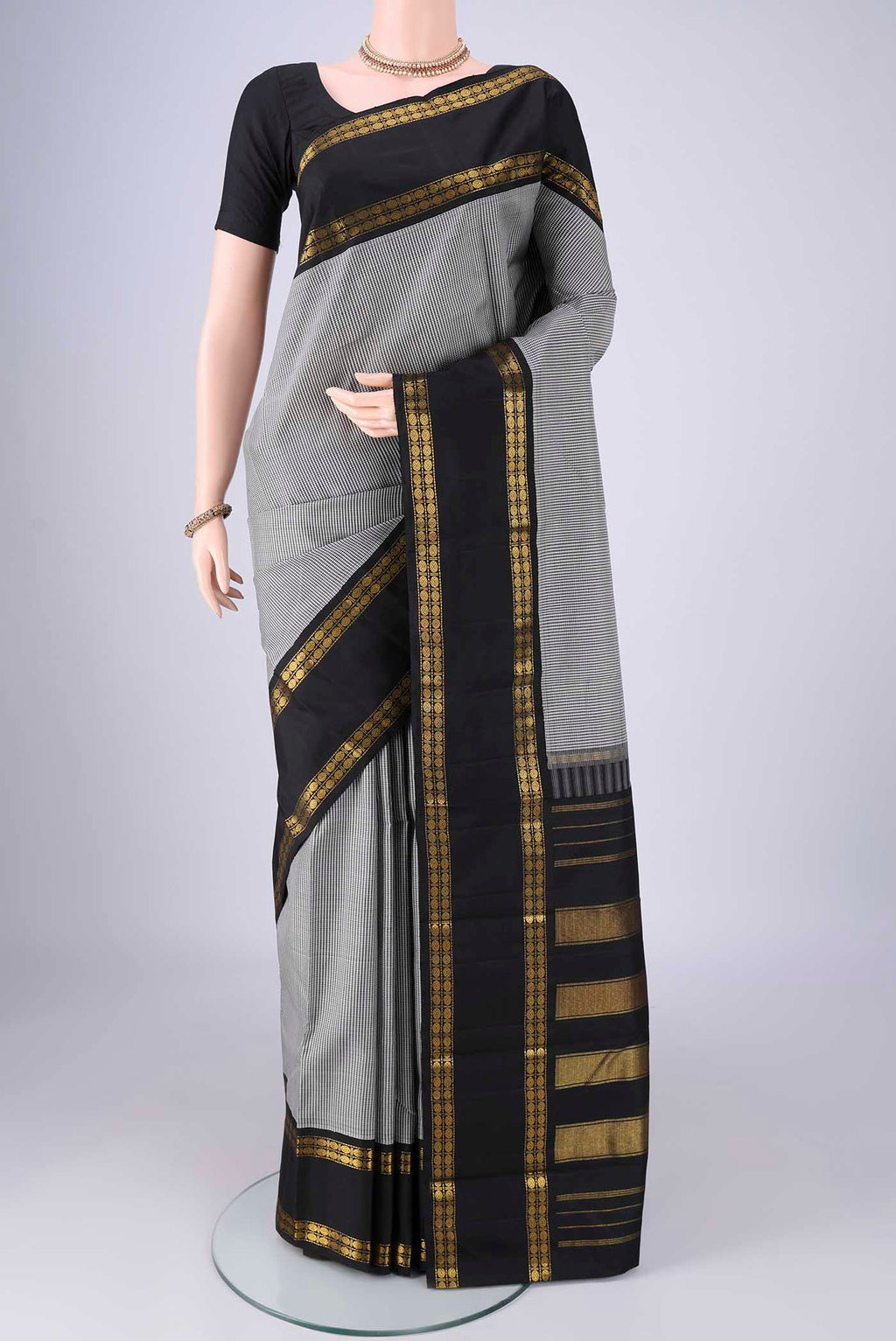 White Kanchipuram Silk Saree with Checked design on the body and Zari Border.  displayed on a mannequin
