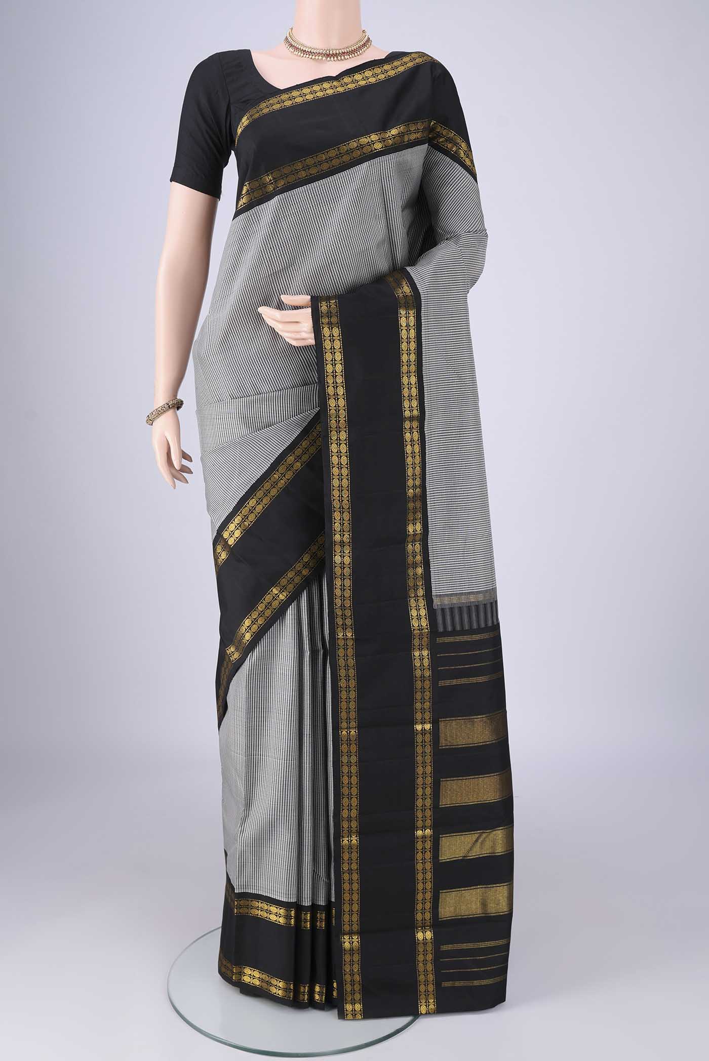 White Kanchipuram Silk Saree with Checked design on the body and Zari Border.  displayed on a mannequin