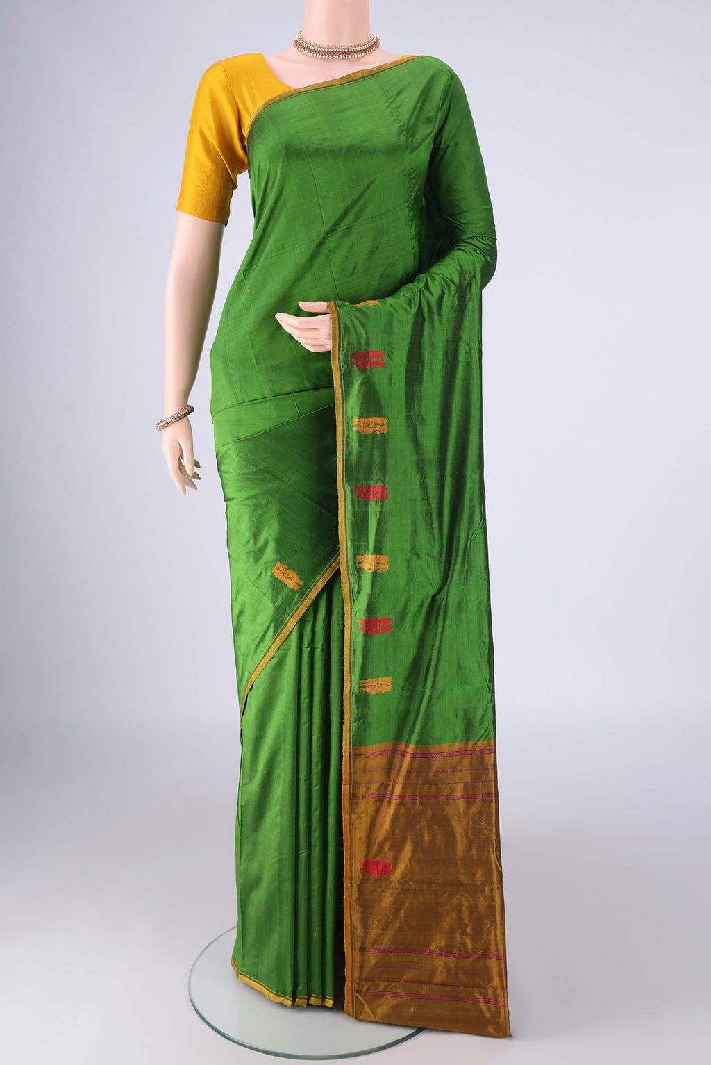 Green Kanchipuram Silk Saree with Plain Body and Thread Border.  displayed on a mannequin