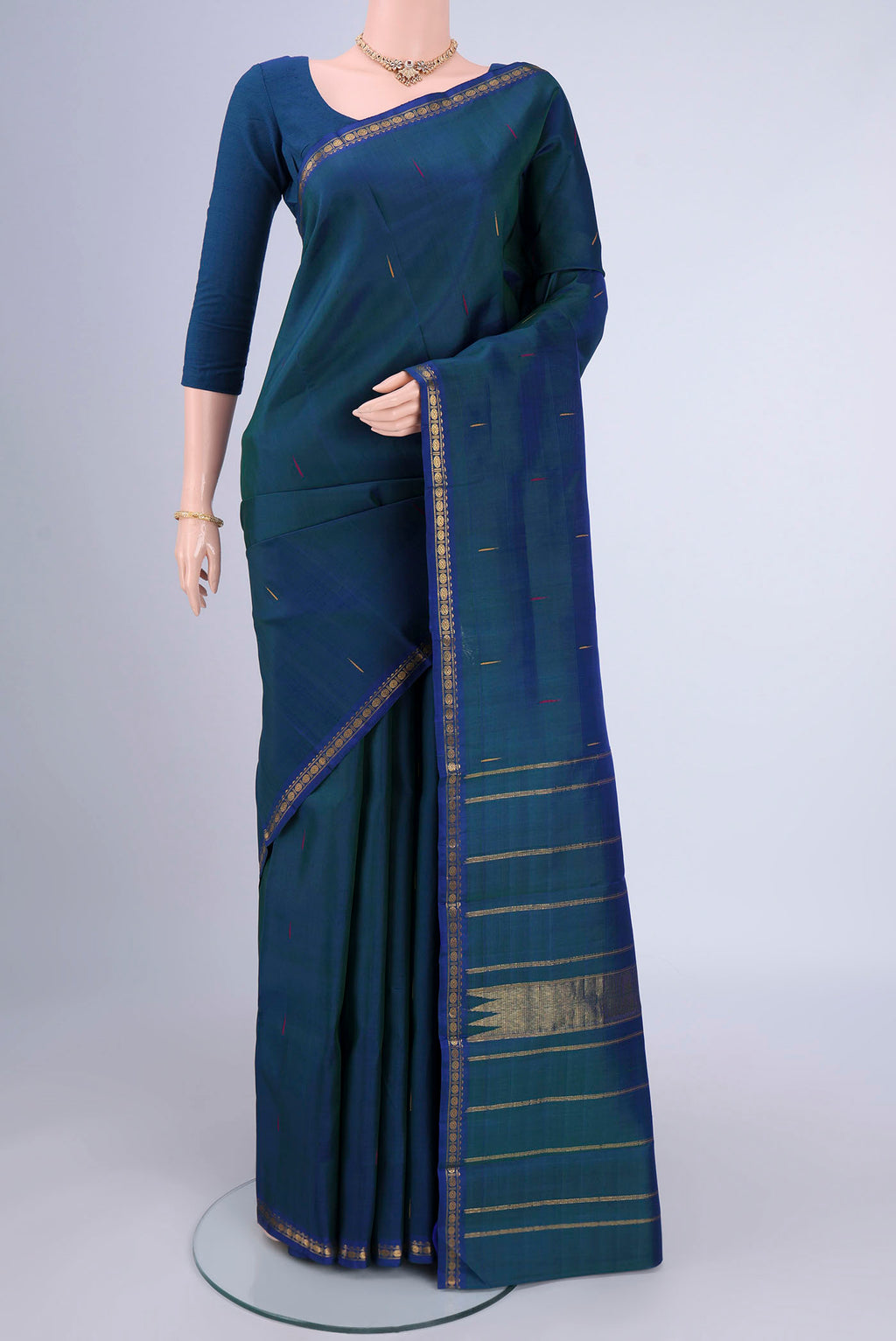 Peacock Blue Kanchipuram Silk Saree with Zari Butta on the body and Zari Border.  displayed on a mannequin