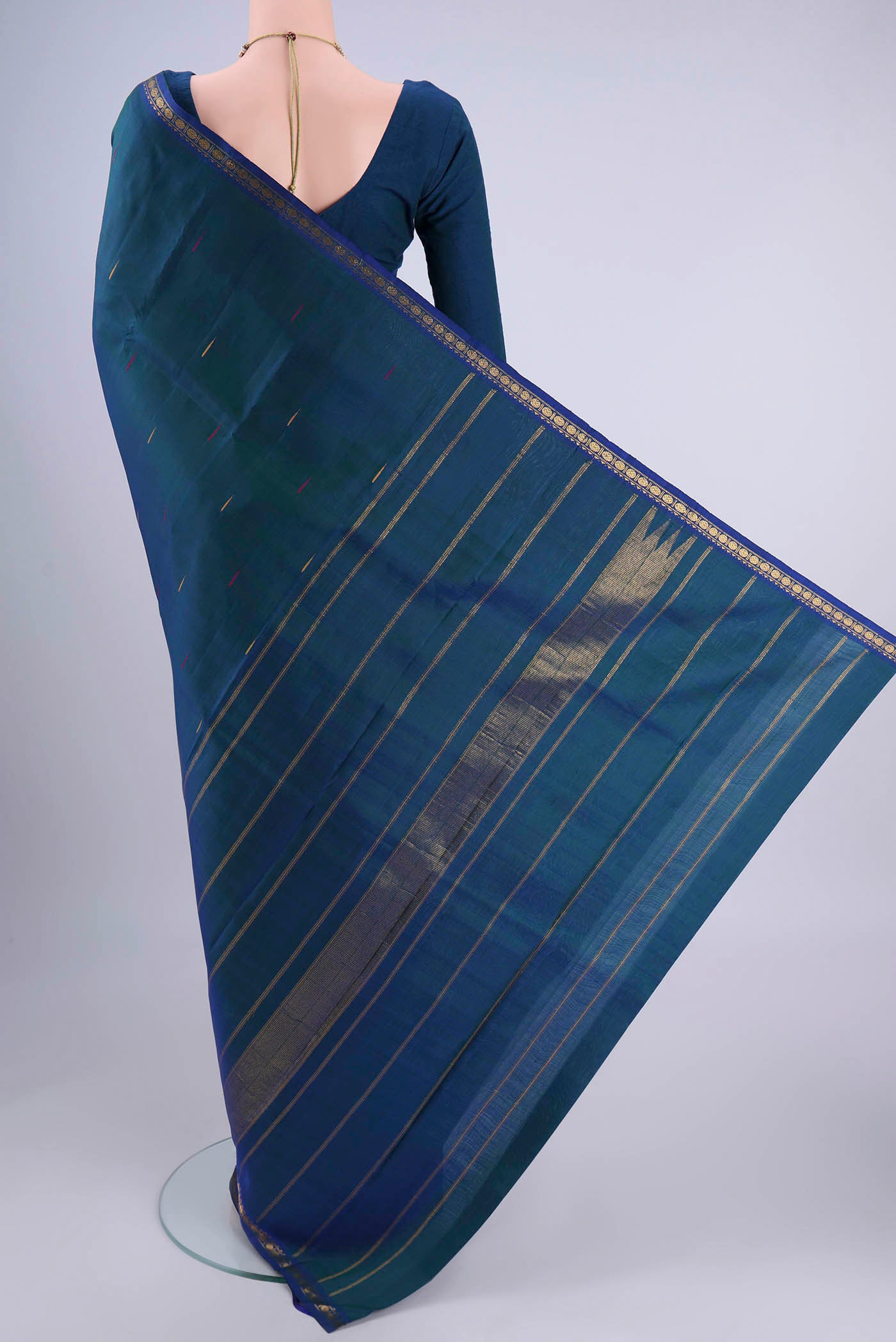 Flat view of Peacock Blue Kanchipuram Silk Saree with Zari Butta on the body and Zari Border. 