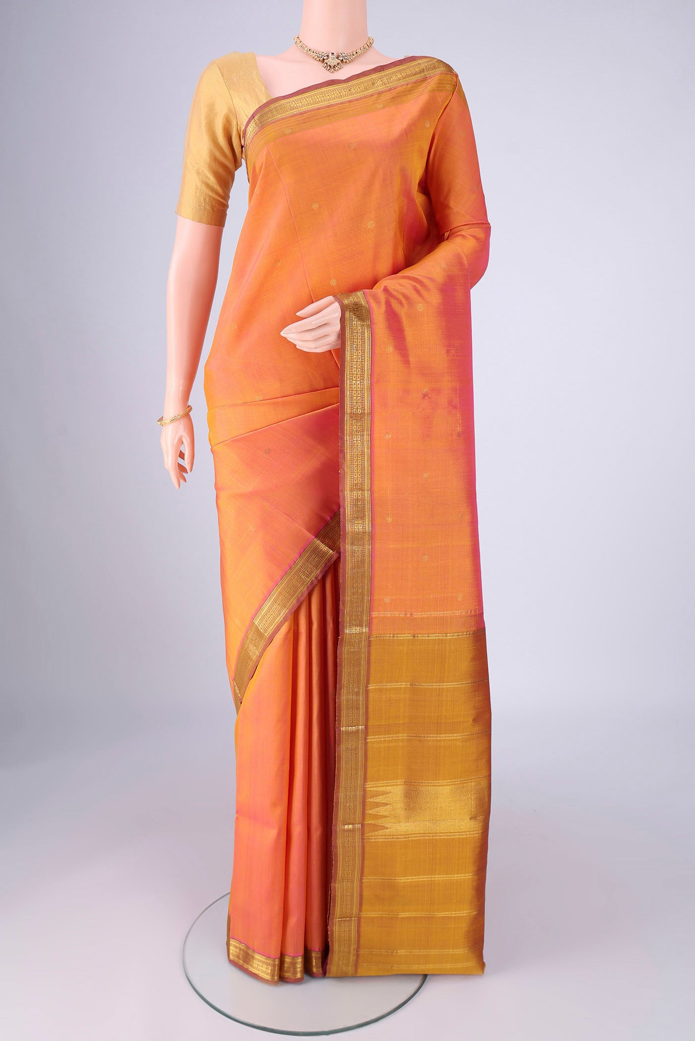 Peach Dual Tone Kanjivaram Silk Saree with Zari Butta on the body and Zari Border.  displayed on a mannequin