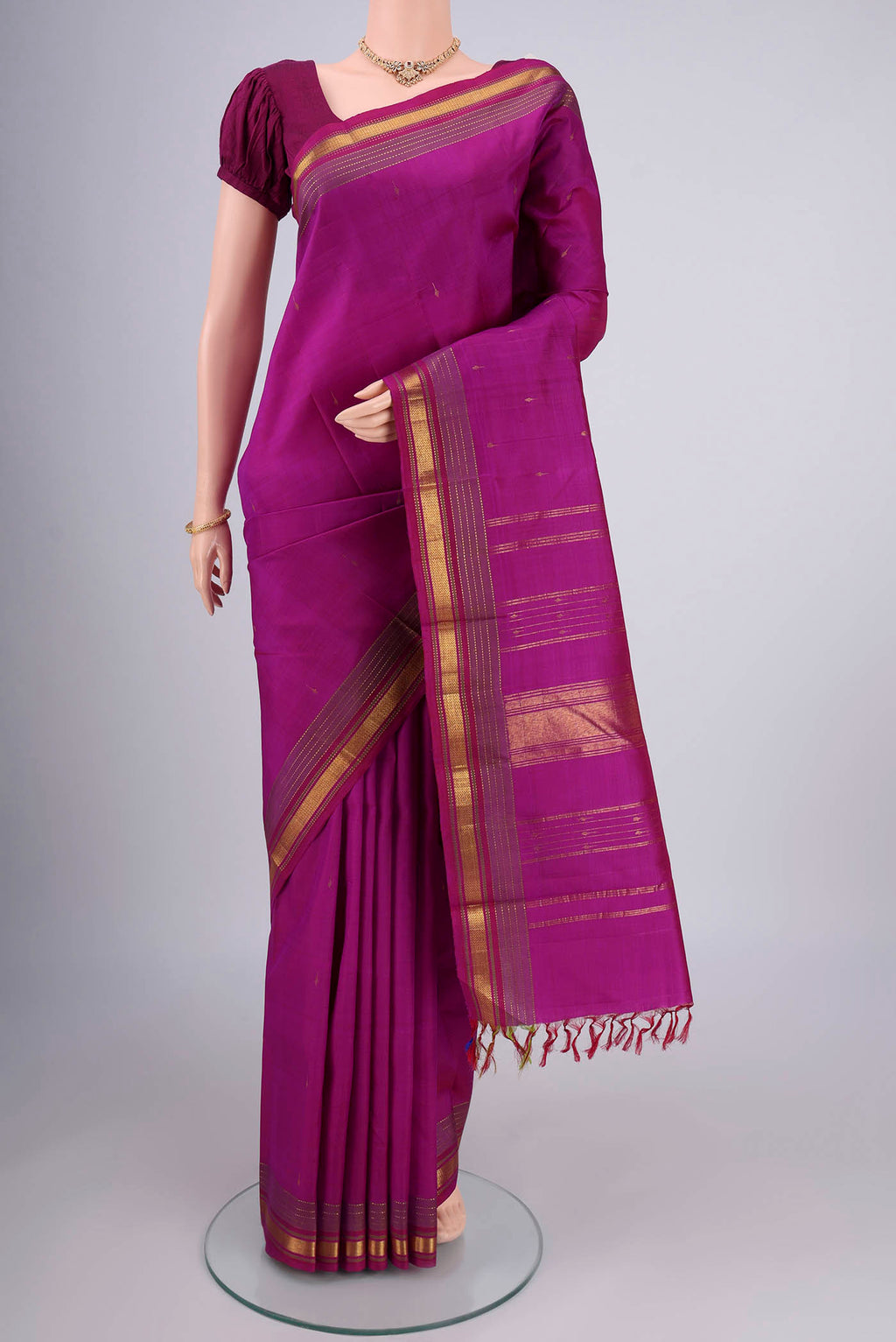 Magenta Kanjivaram Silk Saree with Zari Butta on the body and Zari Border.  displayed on a mannequin