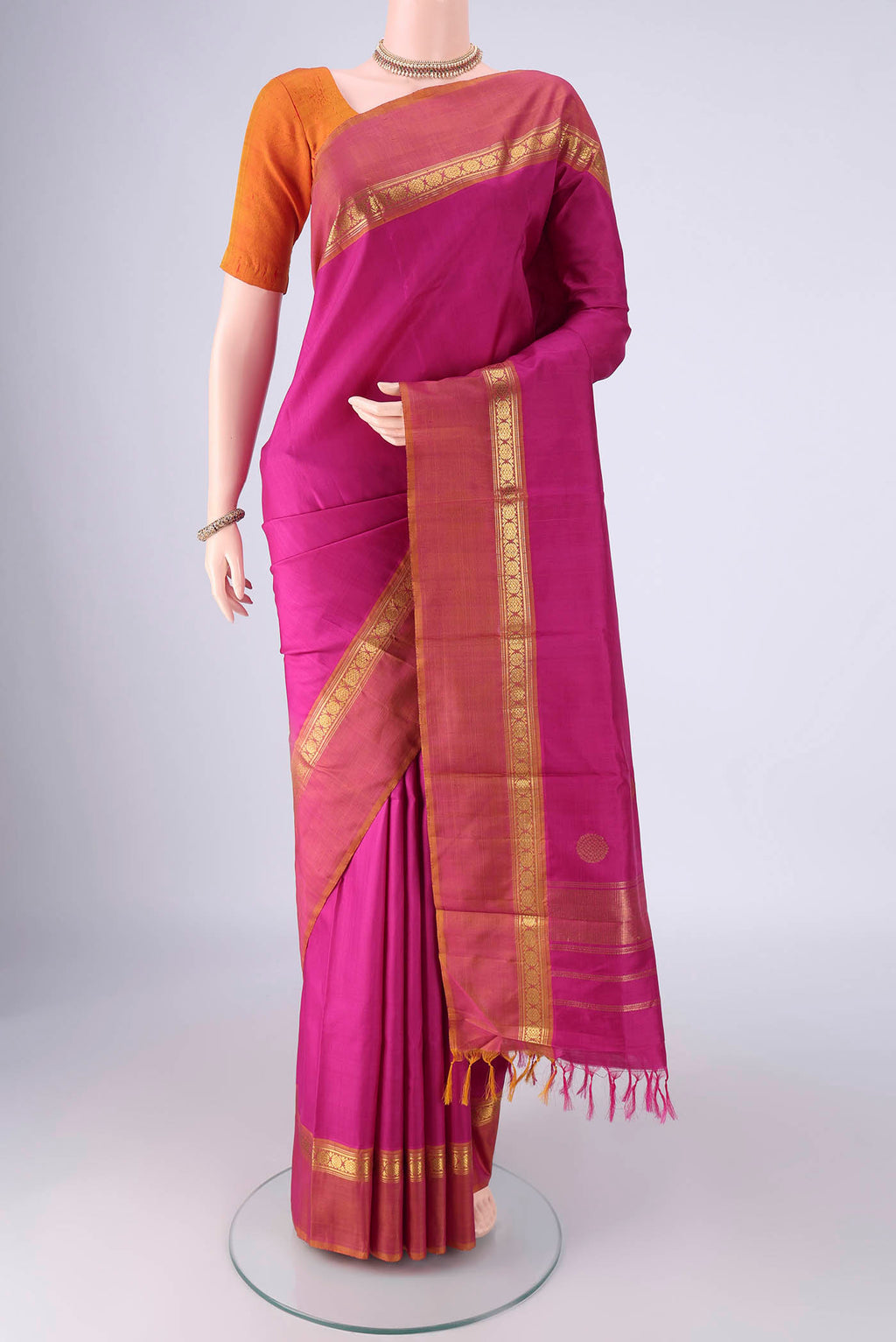 Magenta Kanjivaram Silk Saree with Plain Body and Zari Border.  displayed on a mannequin
