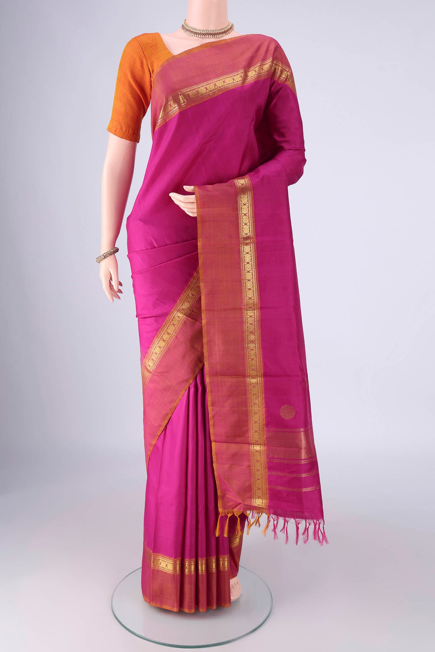 Magenta Kanjivaram Silk Saree with Plain Body and Zari Border.  displayed on a mannequin