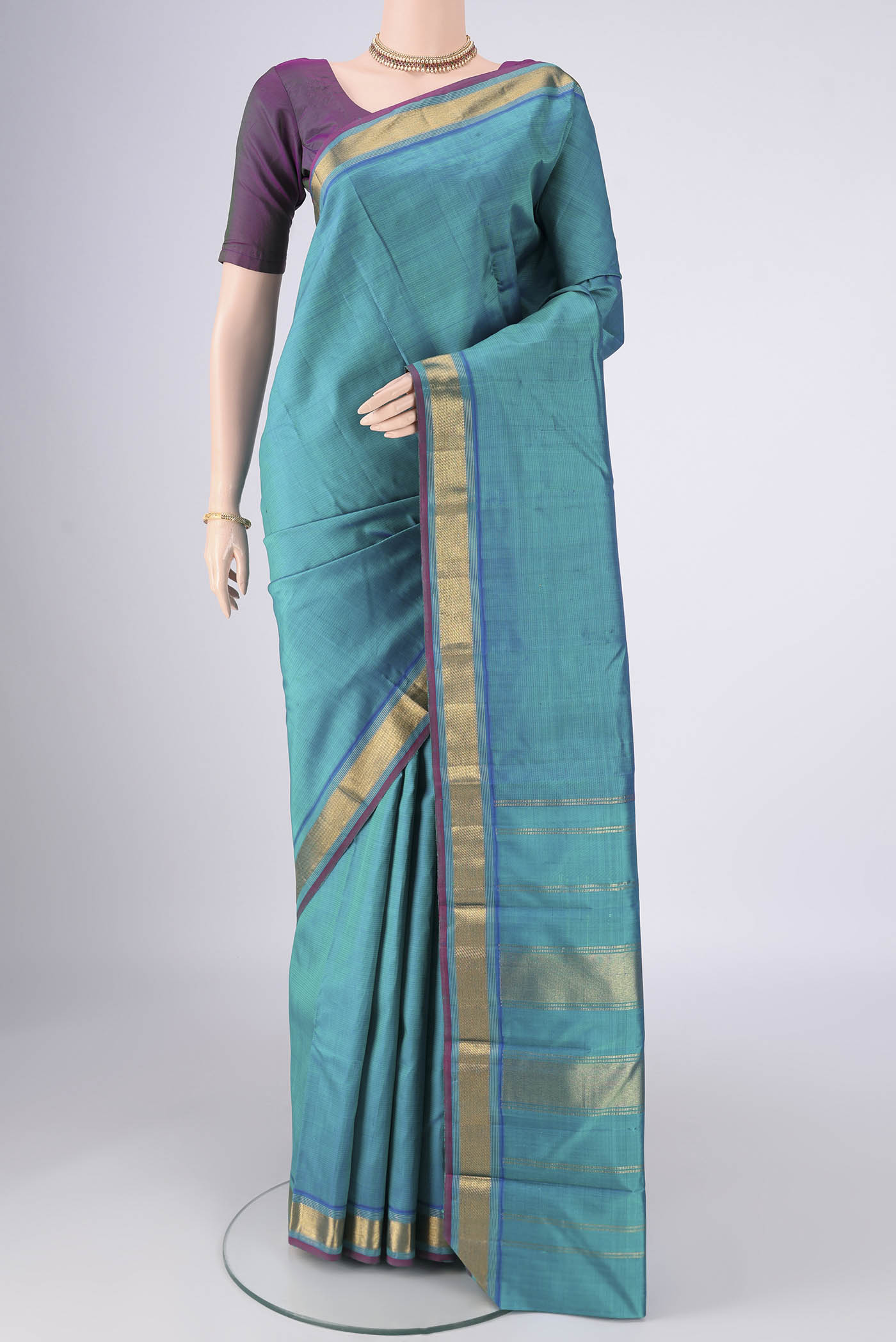 Turquoise Kanjivaram Silk Saree with Plain Body and Zari Border.  displayed on a mannequin