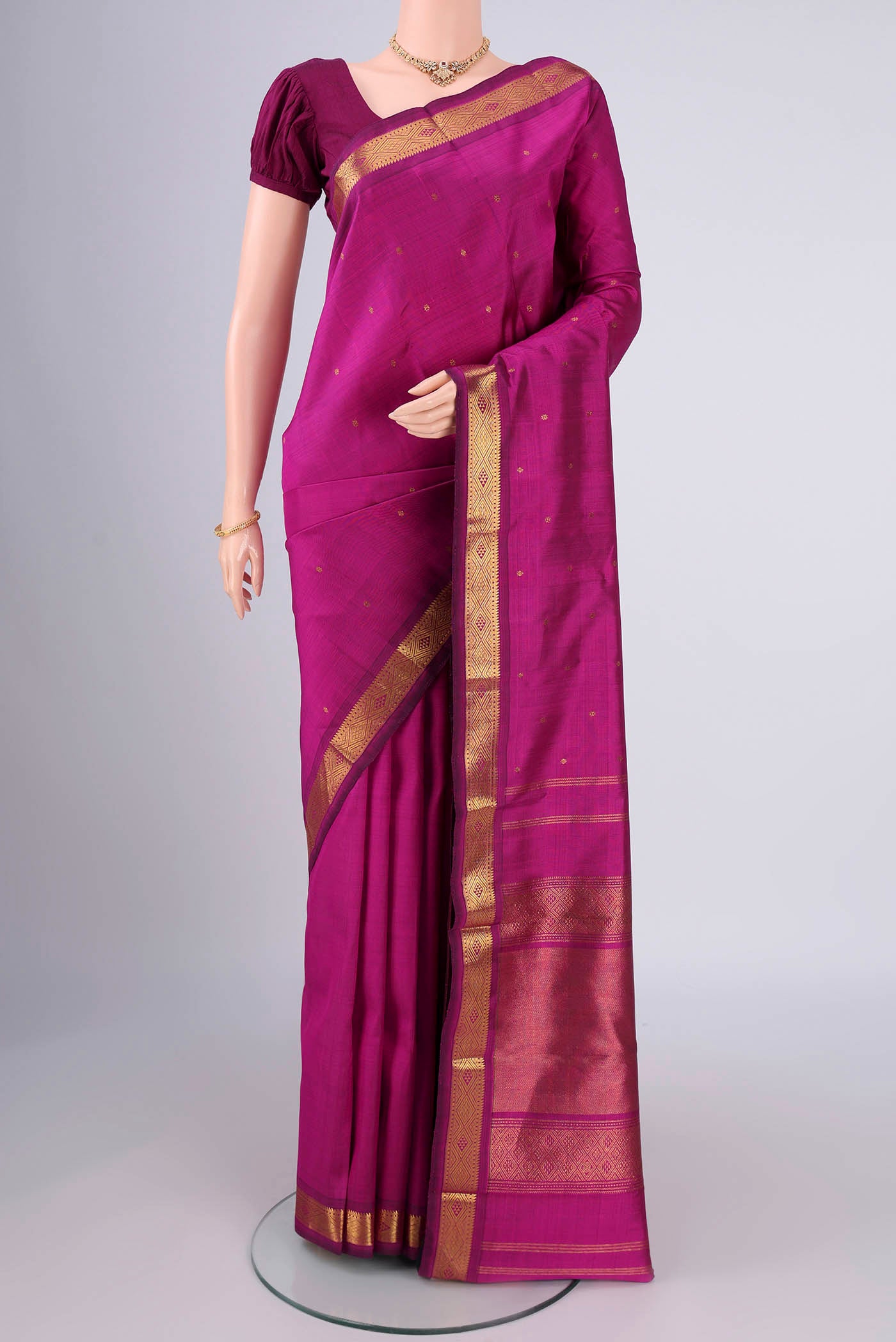 Magenta Kanchipuram Silk Saree with Zari Butta on the body and Zari Border.  displayed on a mannequin