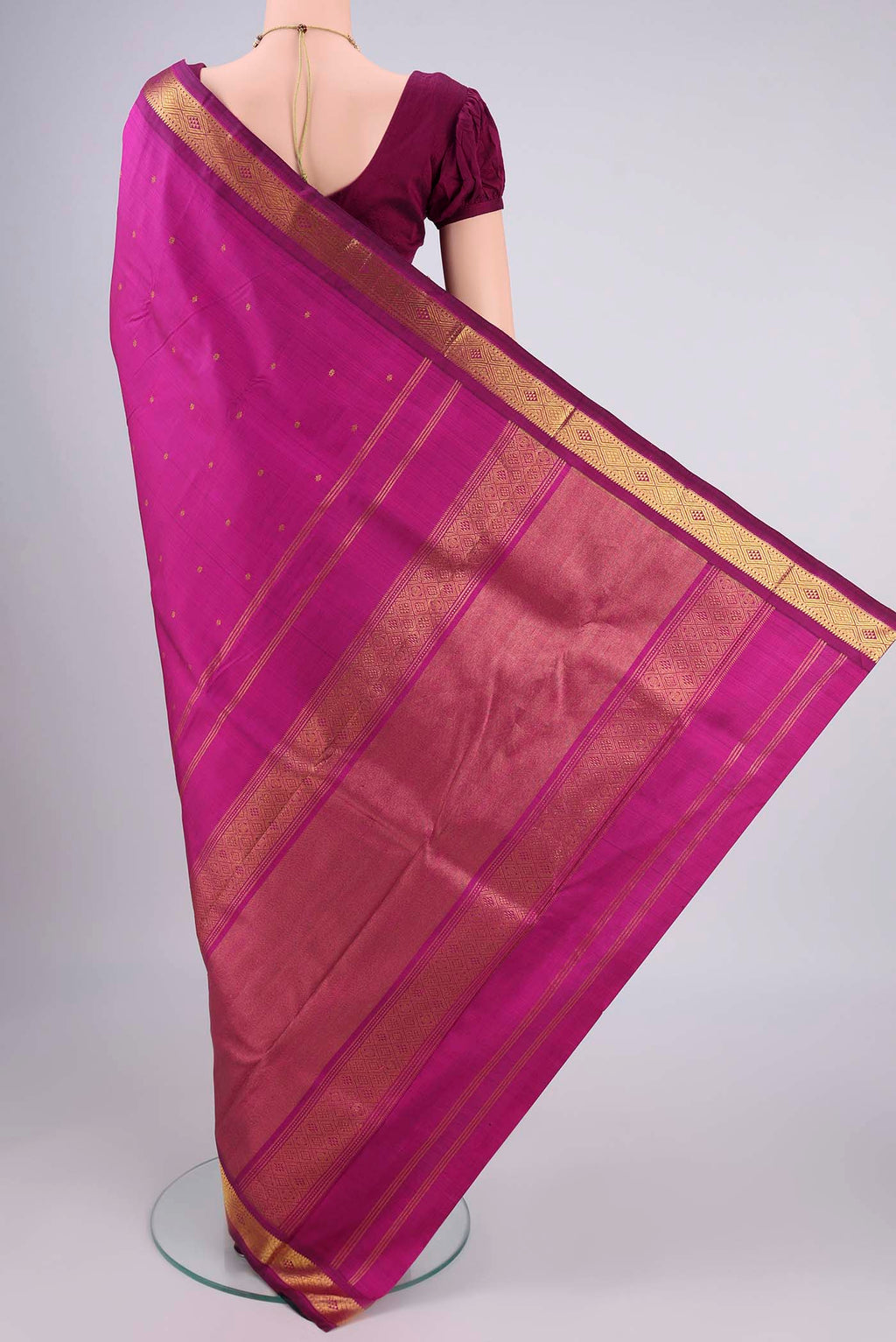 Flat view of Magenta Kanchipuram Silk Saree with Zari Butta on the body and Zari Border. 