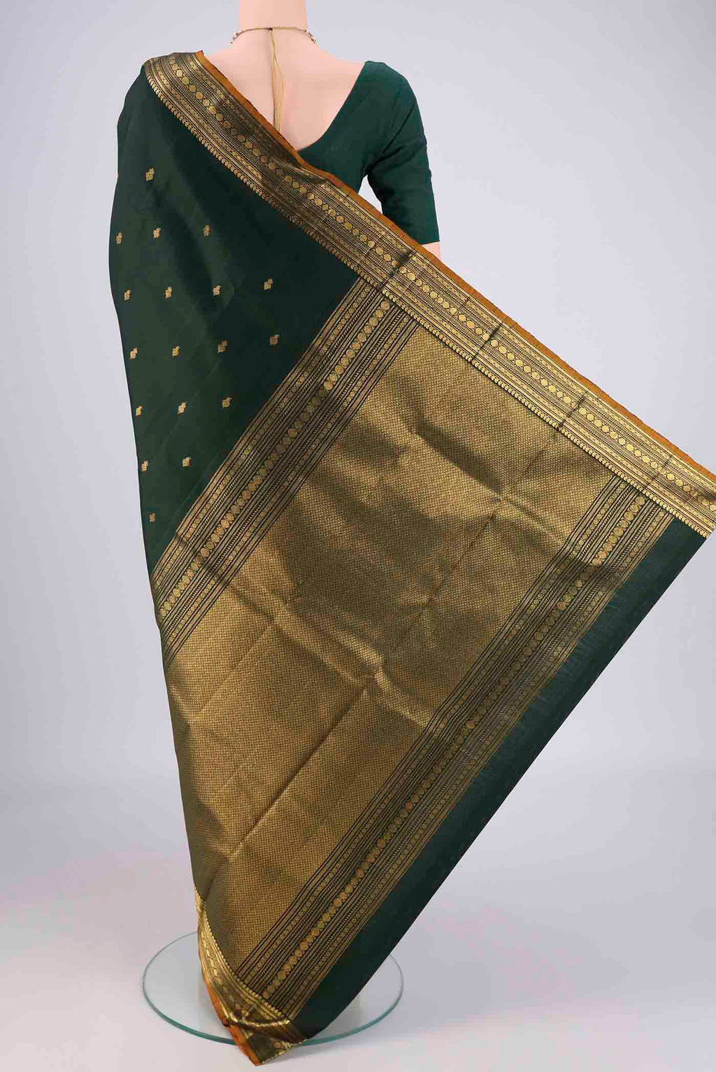 Flat view of Bottle Green Kanjivaram Silk Saree with Zari Butta on the body and Zari Border. 