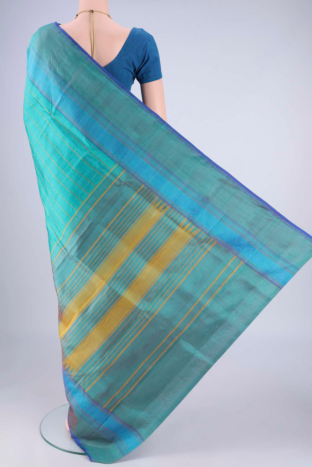 Flat view of Turquoise Kanchipuram Silk Saree with Veldhari on the body and Plain Border. 