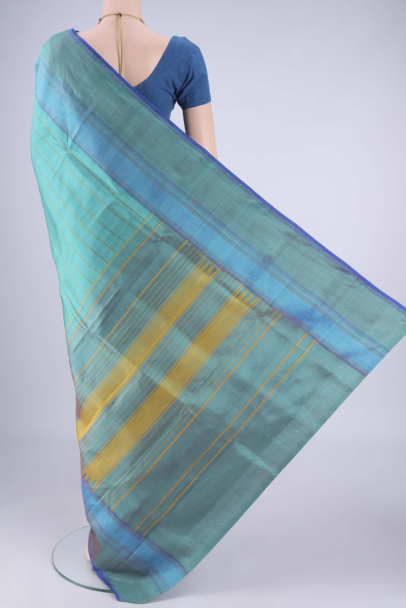 Flat view of Turquoise Kanchipuram Silk Saree with Veldhari on the body and Plain Border. 