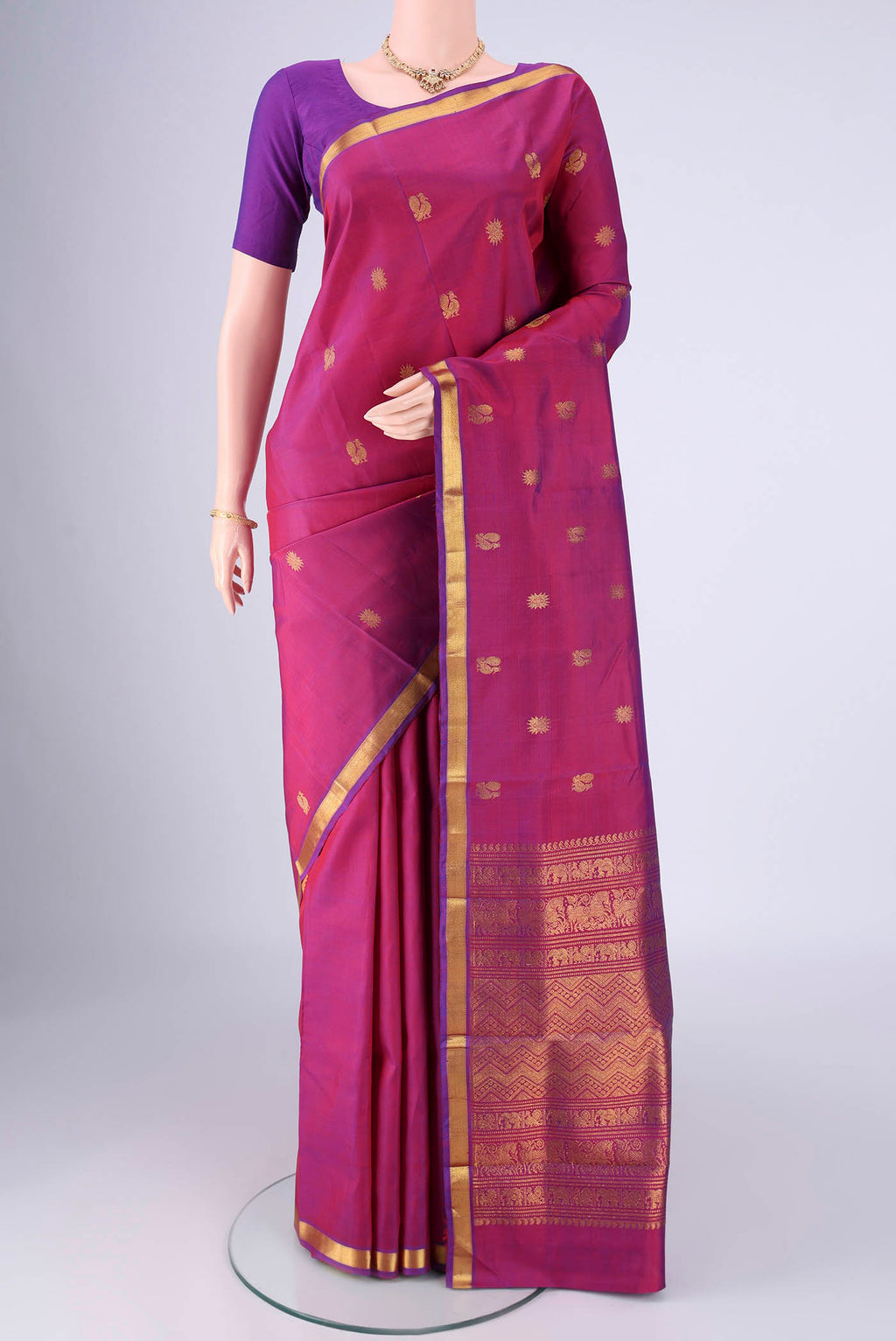 Magenta Kanjivaram Silk Saree with Zari Butta on the body and Zari Border.  displayed on a mannequin