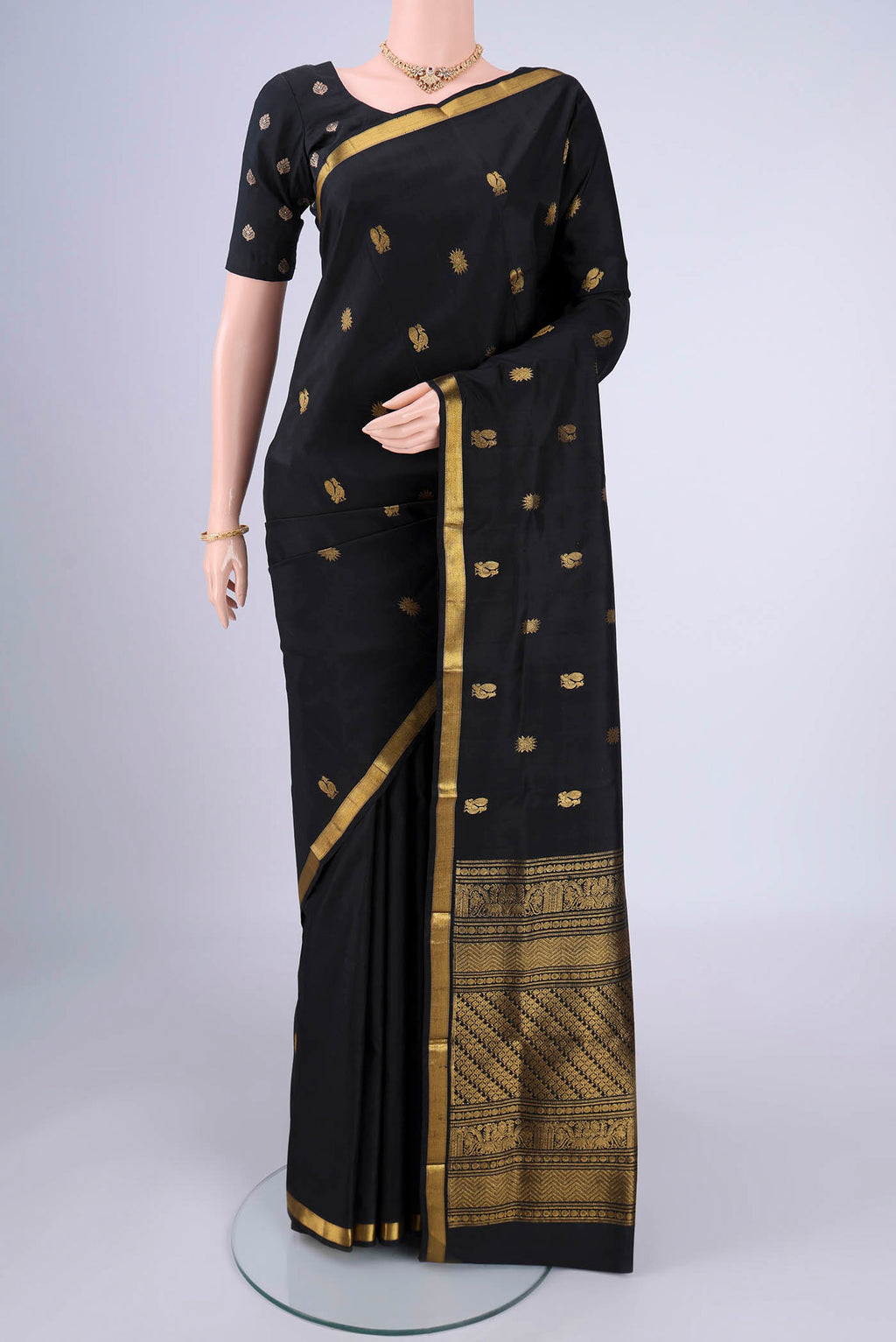 Black Kanjivaram Silk Saree with Zari Butta on the body and Zari Border.  displayed on a mannequin