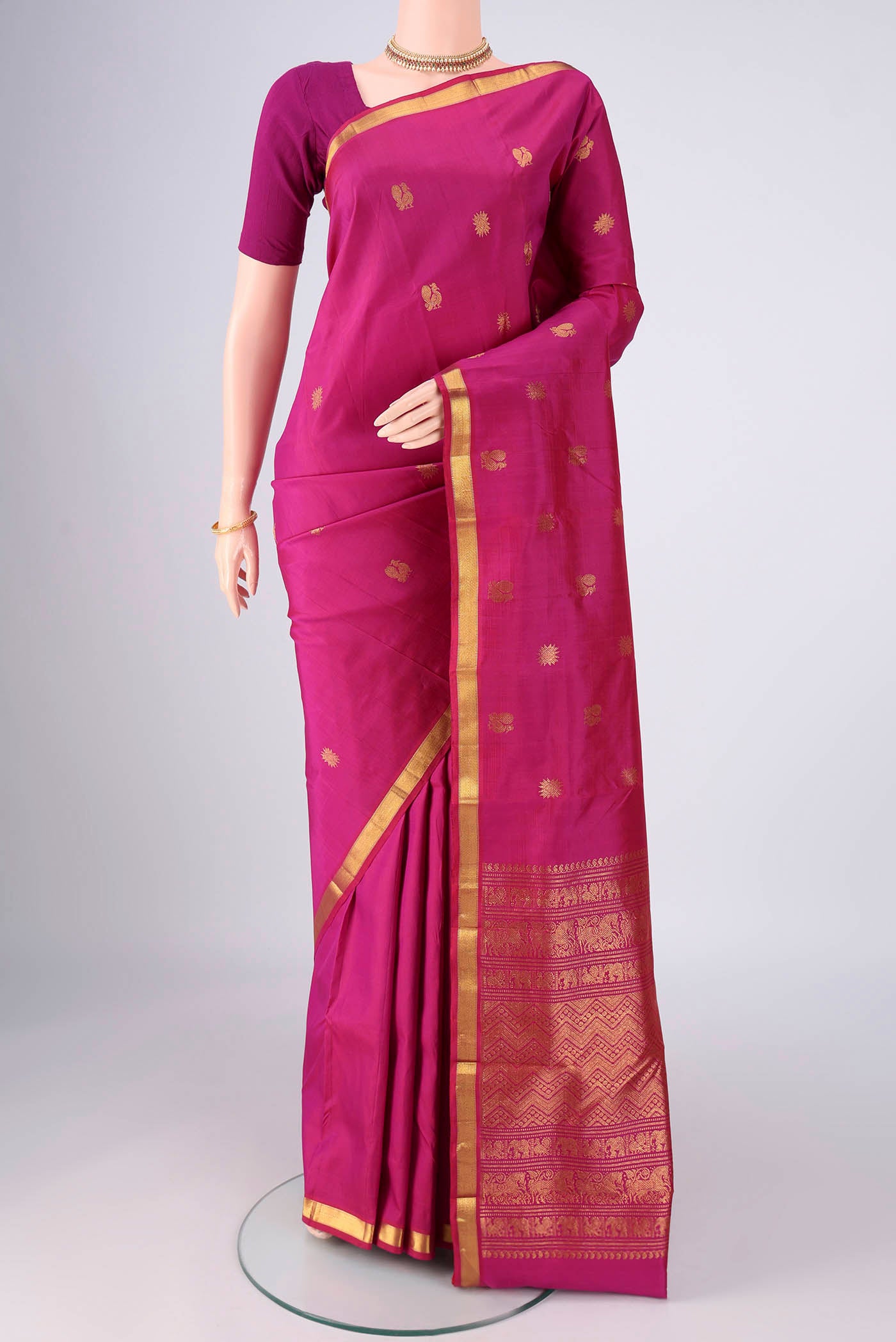 Magenta Kanjivaram Silk Saree with Zari Butta on the body and Zari Border.  displayed on a mannequin