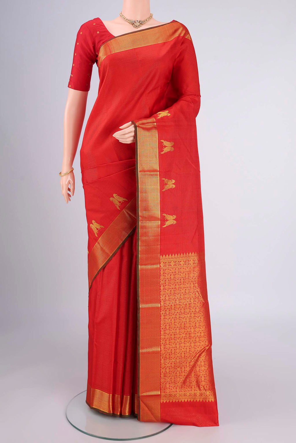 Orange Kanjivaram Silk Saree with Stripes on the body and Zari Border.  displayed on a mannequin
