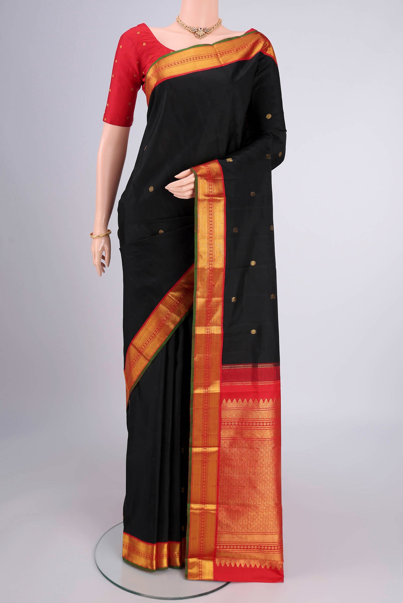 Black Kanjivaram Silk Saree with Zari Butta on the body and Zari Border.  displayed on a mannequin