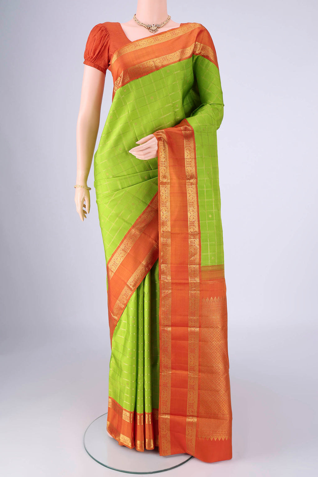 Parrot Green Kanjivaram Silk Saree with Checked design on the body and Zari Border.  displayed on a mannequin