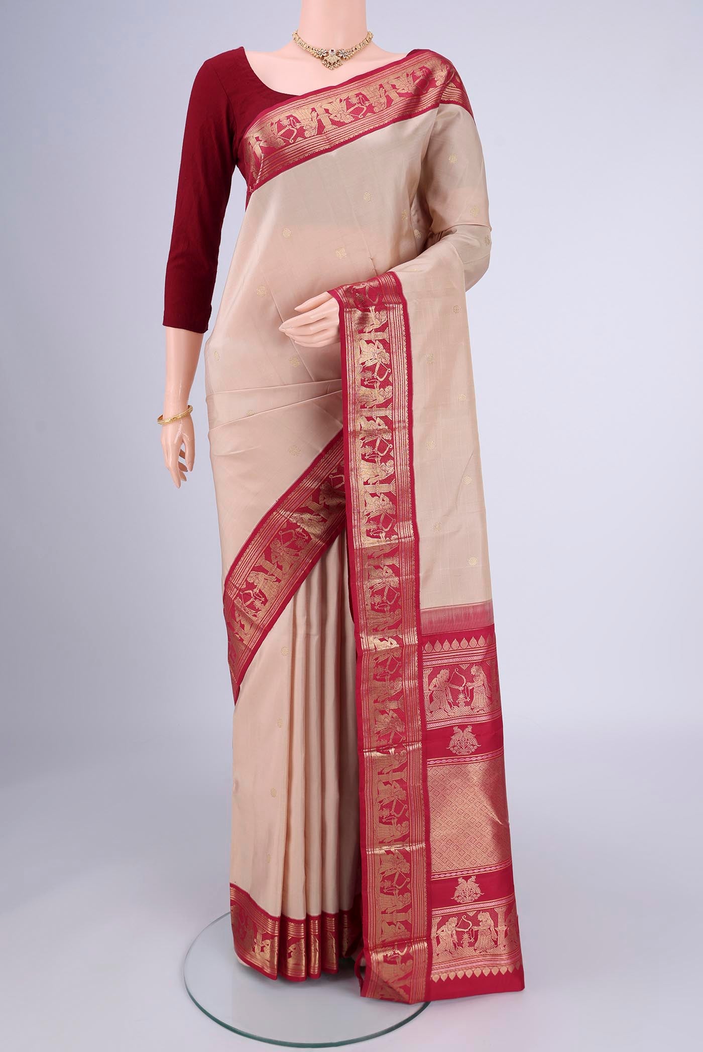 Beige Kanjivaram Silk Saree with Zari Butta on the body and Zari Border.  displayed on a mannequin