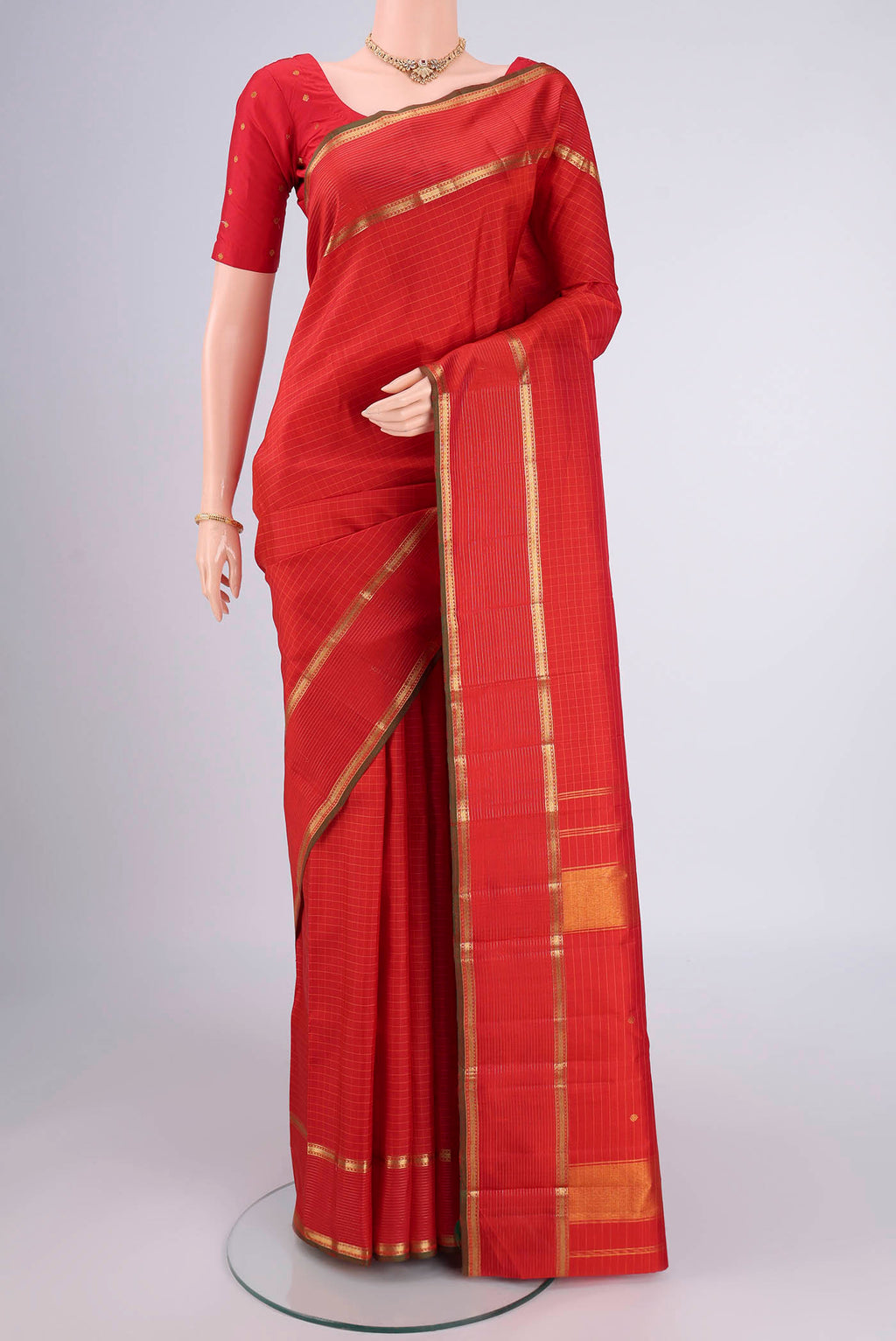 Red Kanchipuram Silk Saree with Checked design on the body and Zari Border.  displayed on a mannequin