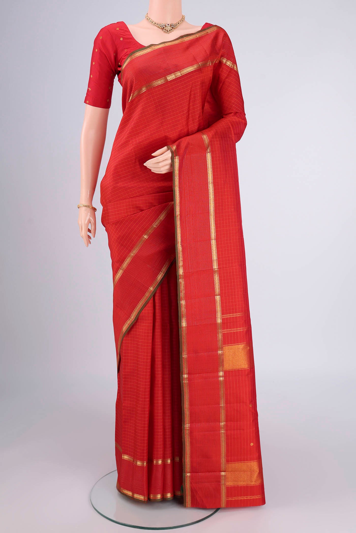 Red Kanchipuram Silk Saree with Checked design on the body and Zari Border.  displayed on a mannequin