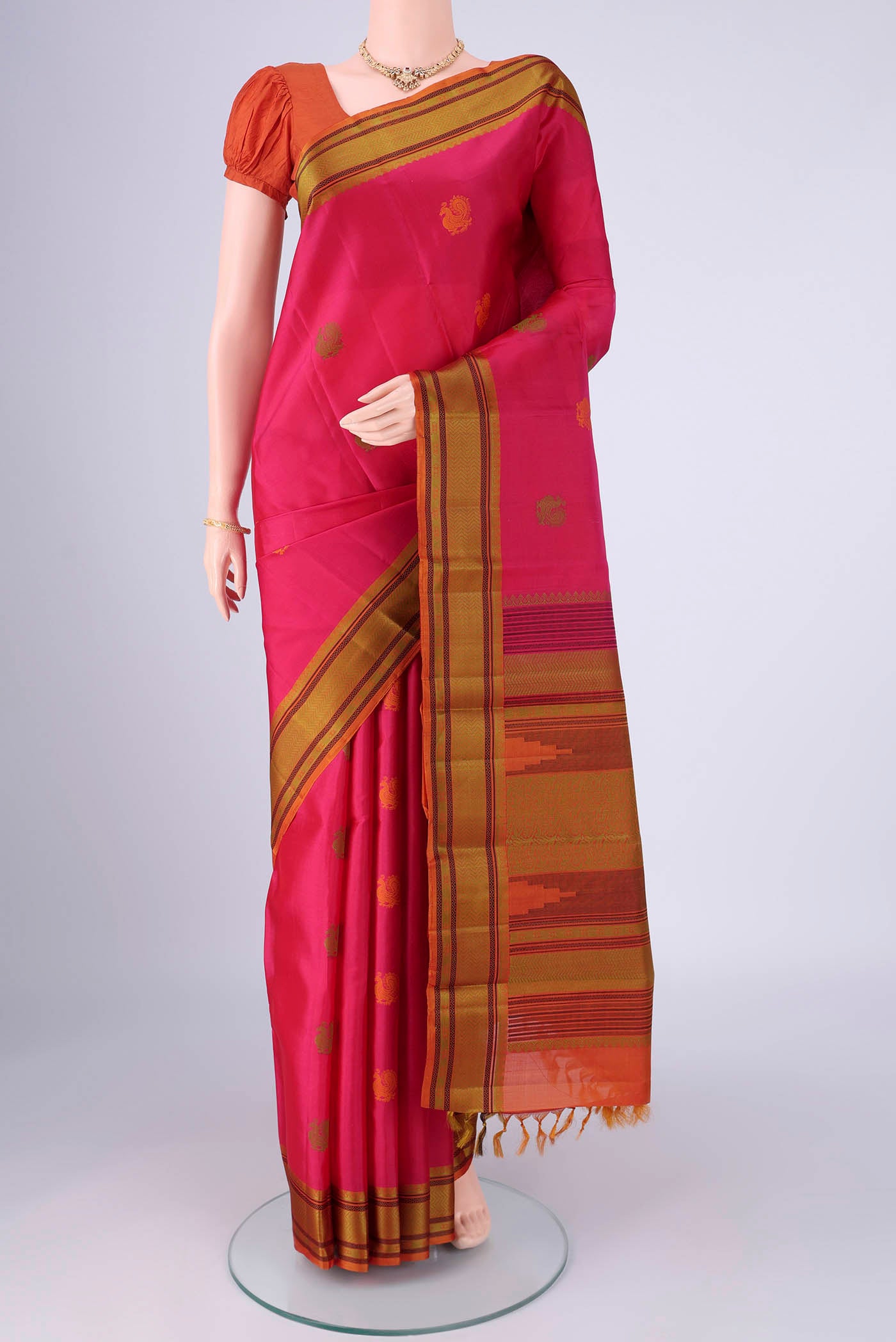 Dark Pink Kanchipuram Silk Saree with Thread Butta on the body and Thread Border.  displayed on a mannequin