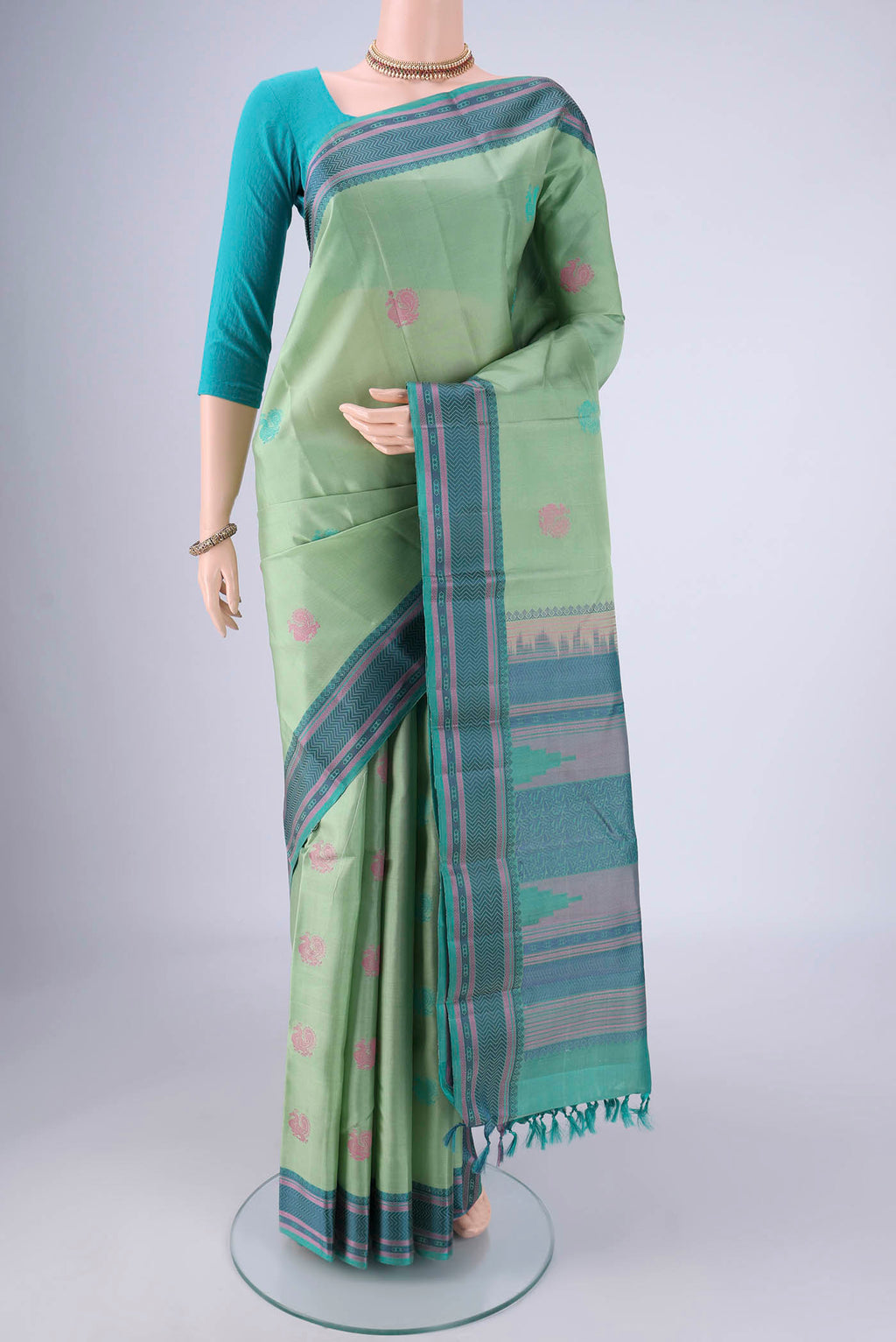 Pista Green Kanchipuram Silk Saree with Thread Butta on the body and Thread Border.  displayed on a mannequin