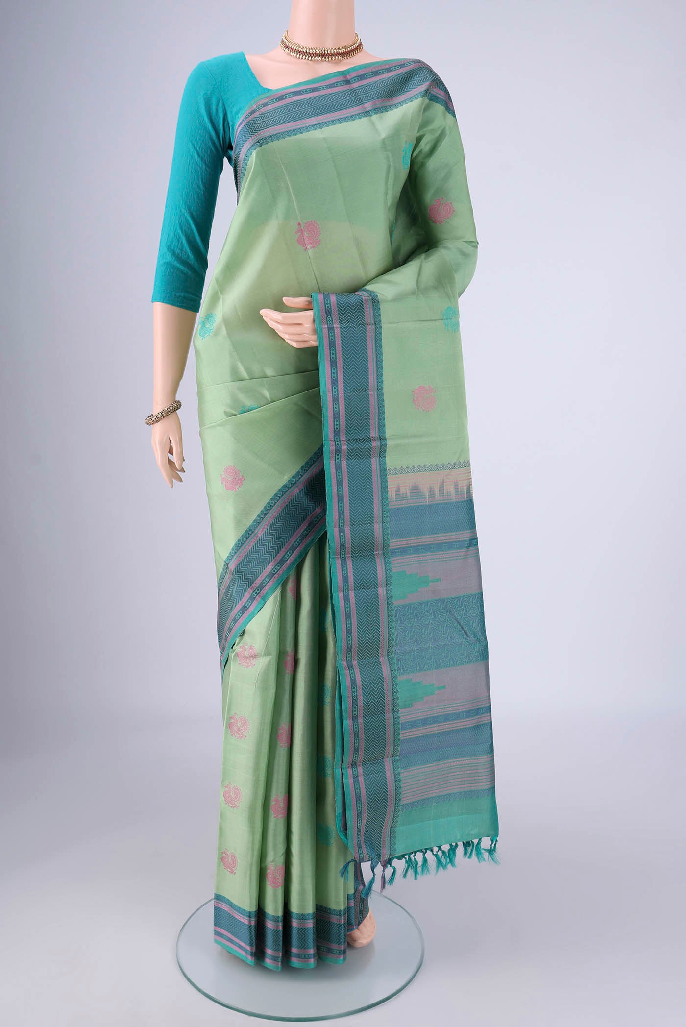 Pista Green Kanchipuram Silk Saree with Thread Butta on the body and Thread Border.  displayed on a mannequin