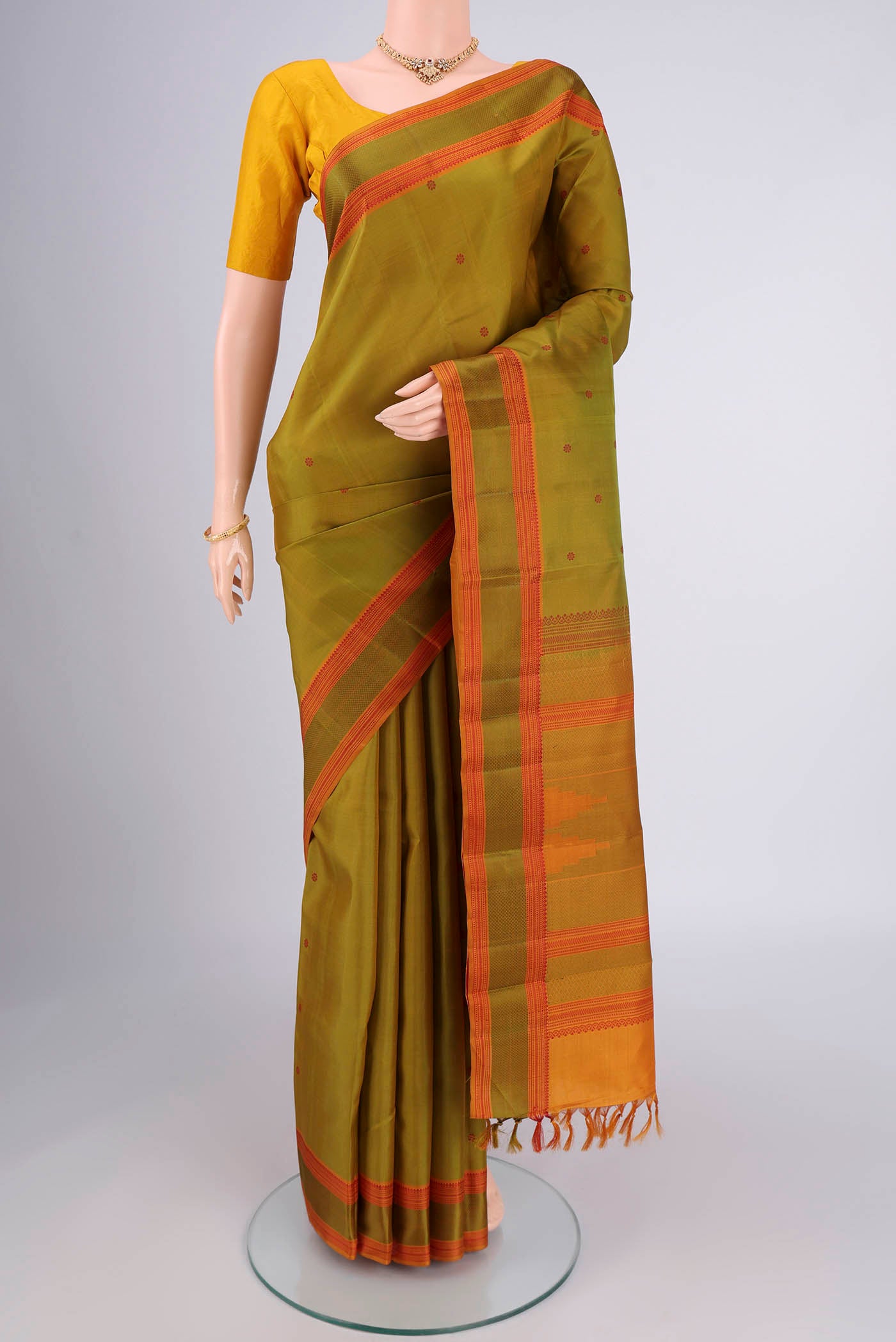 Light Green Kanchipuram Silk Saree with Thread Butta on the body and Thread Border.  displayed on a mannequin