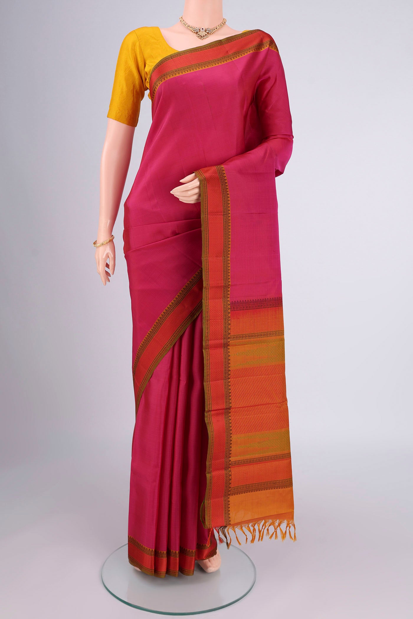 Rani Pink Kanchipuram Silk Saree with Plain Body and Thread Border.  displayed on a mannequin