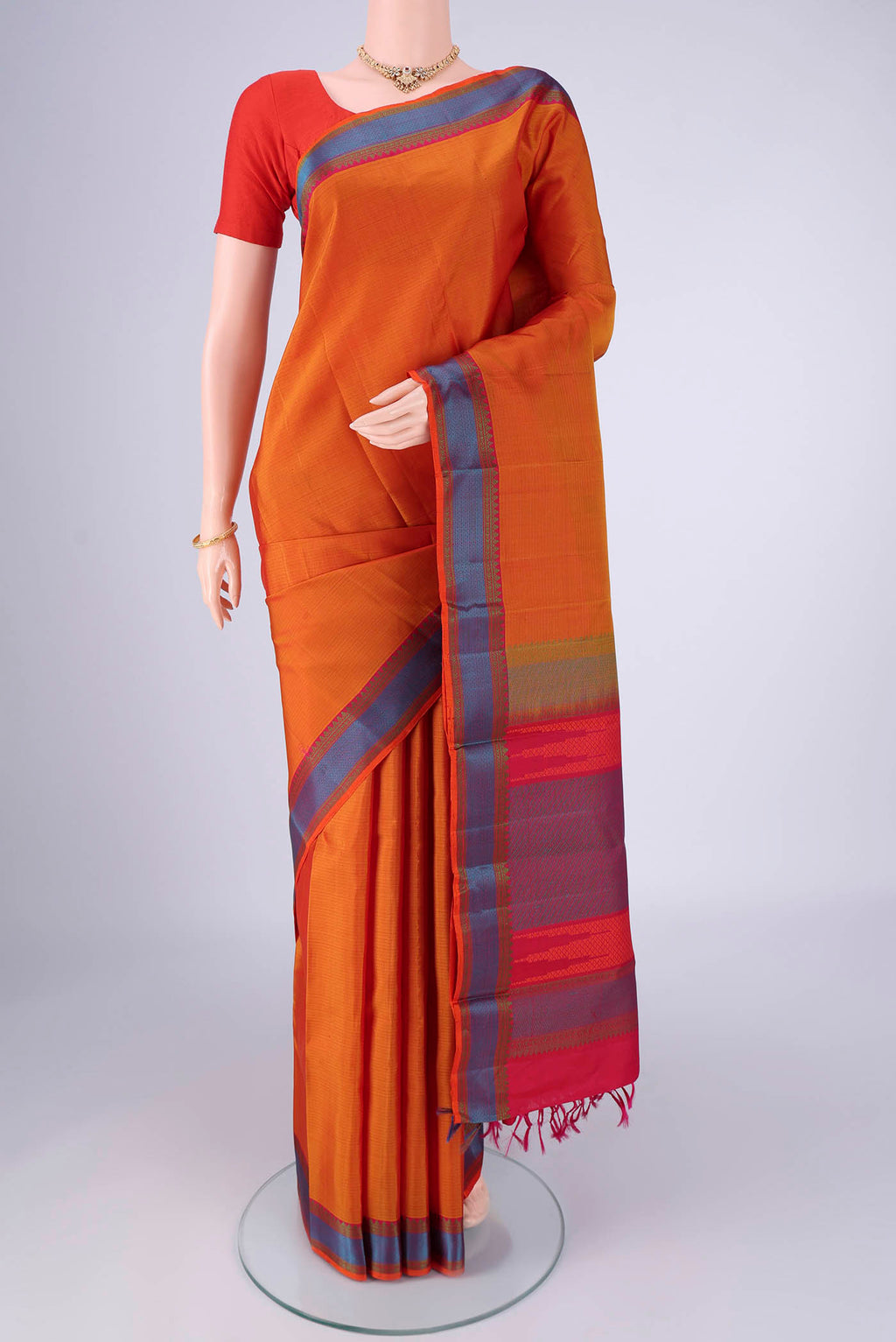 Mustard Kanchipuram Silk Saree with Plain Body and Thread Border.  displayed on a mannequin
