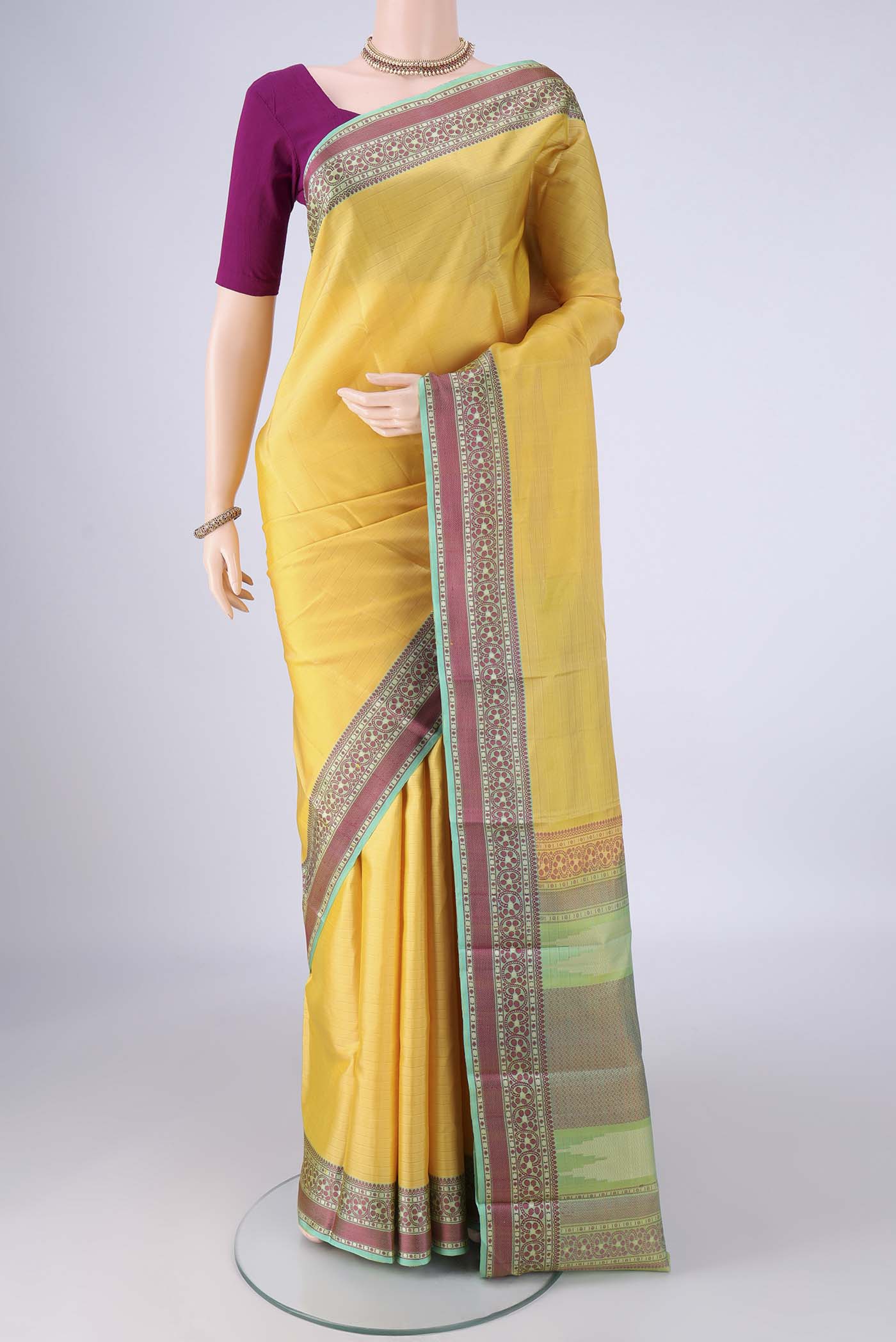 Lemon Yellow Kanchipuram Silk Saree with Plain Body and Thread Border.  displayed on a mannequin