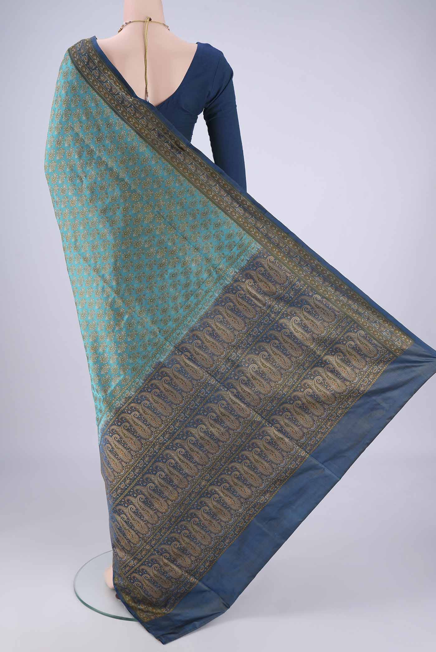 Flat view of Turquoise Banarasi Tanchoi Silk Saree with Jacquard design on the body and Thread Border. 