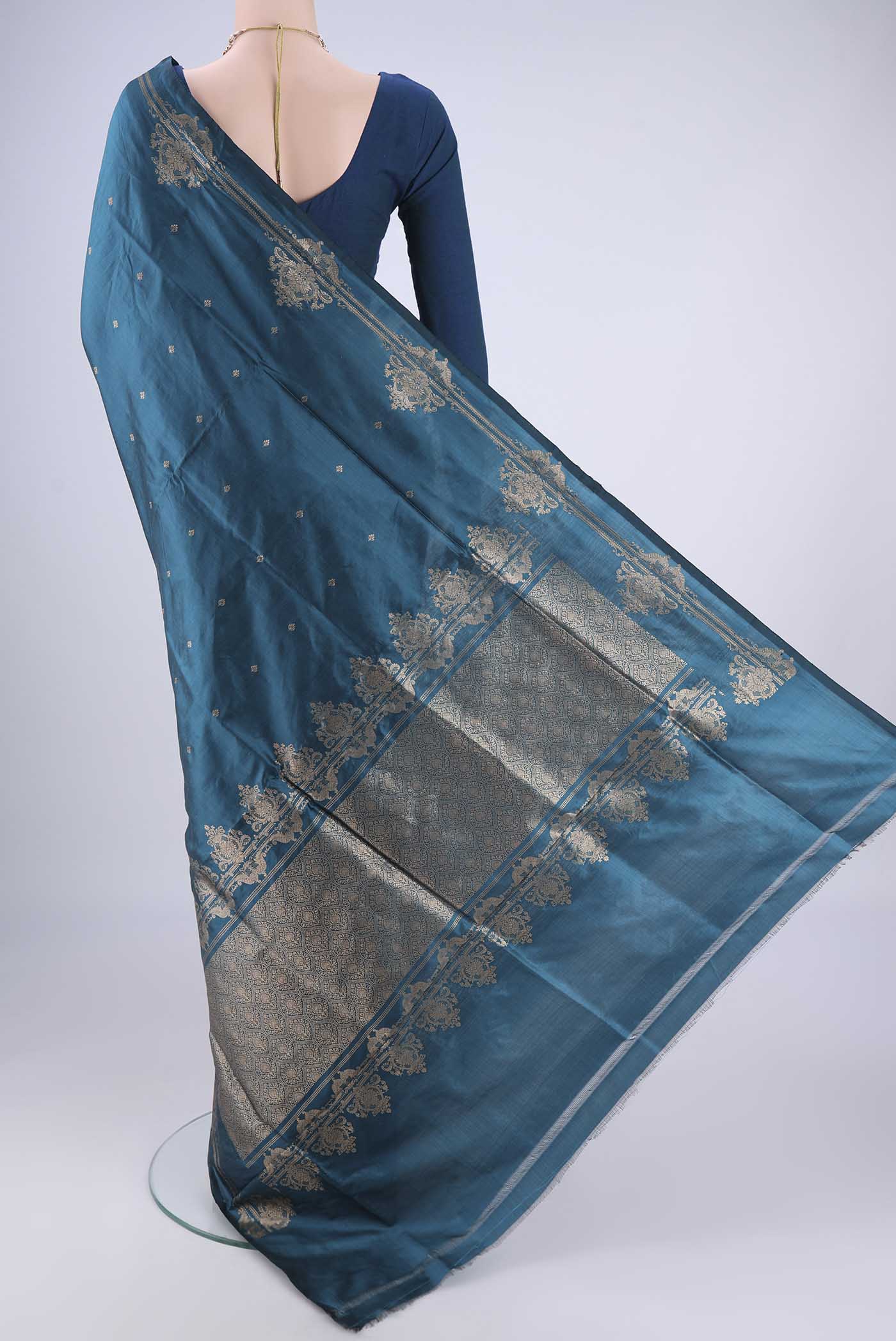 Flat view of Teal Banarasi Katan Silk Saree with Zari Butta on the body and Zari Border. 